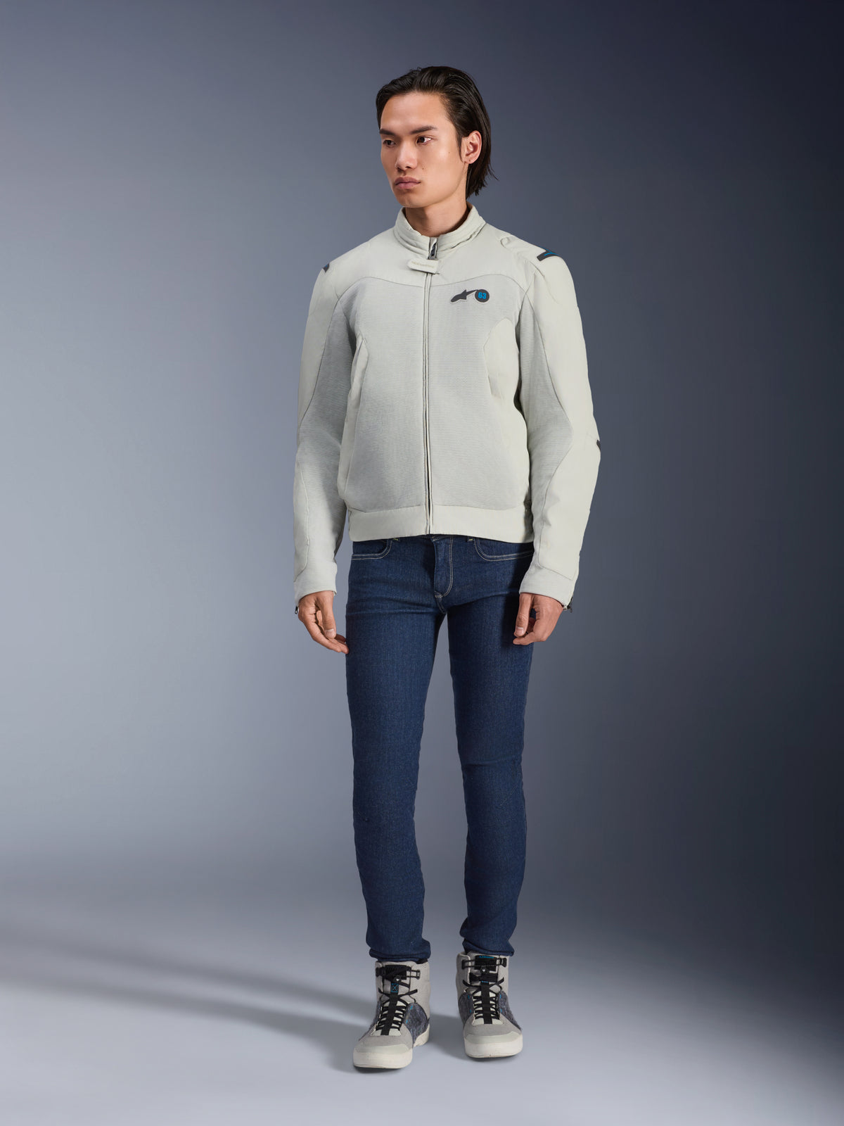 Giacca Alpinestars Circal-1 Air, Metal Gray, giacca da moto urbana con pannelli in rete per il flusso d'aria, indossata da un modello con jeans blu e scarpe da moto grigie, design minimalista per una guida urbana sostenibile.