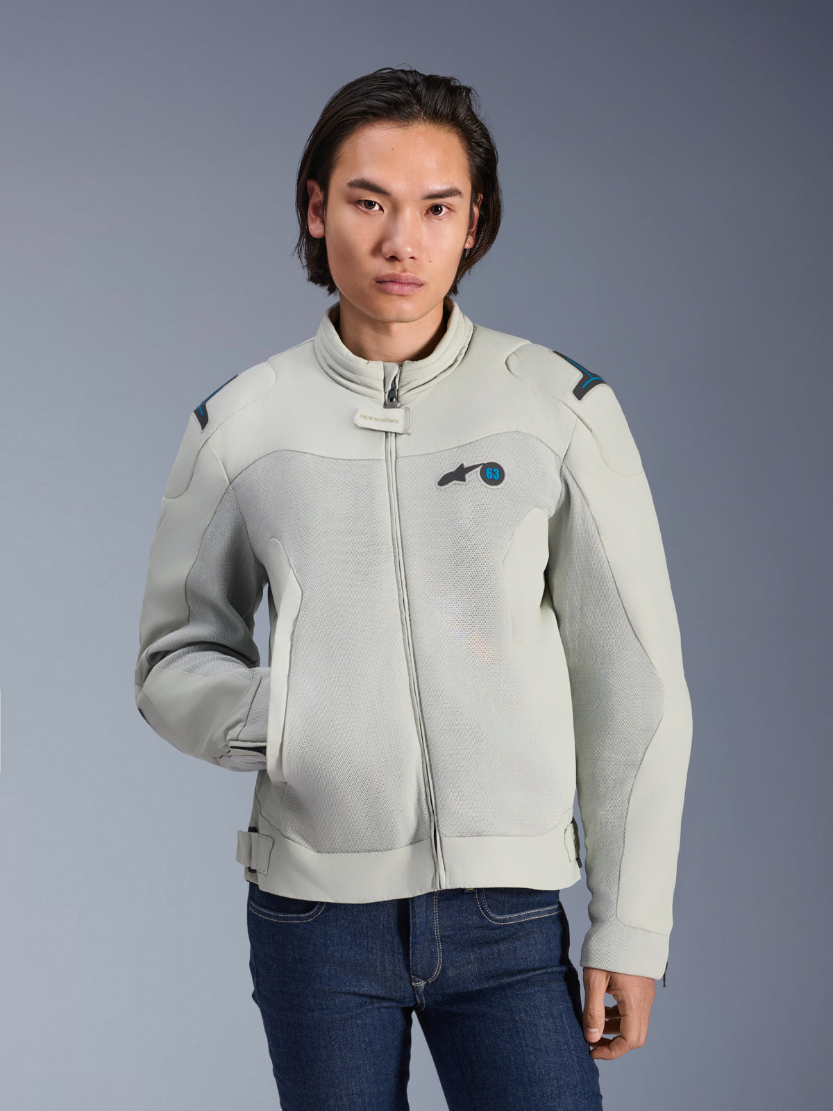 Alpinestars Circal-1 Air Jacket, Metal Gray e Methyl Blue, giacca moto urbana con pannelli in mesh per il flusso d'aria, zip frontale e colletto imbottito, indossata da un modello con jeans blu, design futuristico e sostenibile per la guida estiva