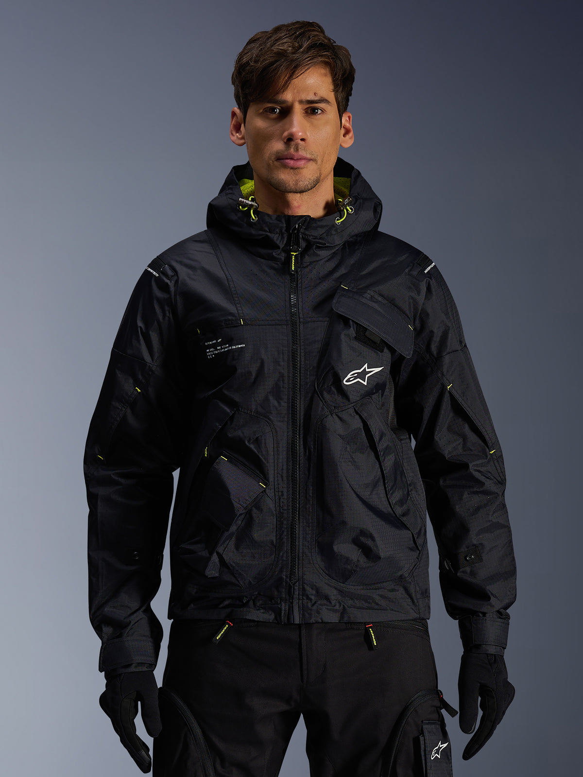 Alpinestars giacca da moto Mogress Air urbana da uomo, nera e Lime Punch, con cappuccio utility, indossata da un modello.