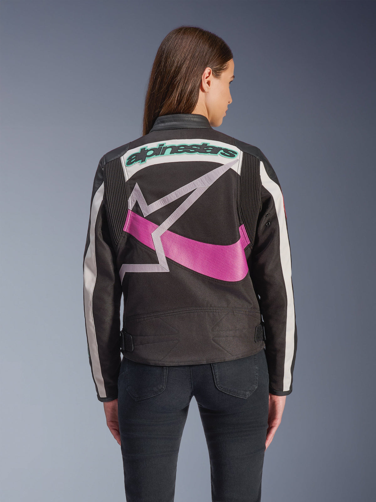 Giacca da donna Alpinestars Idles, vista posteriore, nero, off-white e viola, grande logo grafico a stella sul retro, marchio ricamato color teal, pannelli a fisarmonica sulle spalle, abbigliamento da moto urbano d'ispirazione vintage