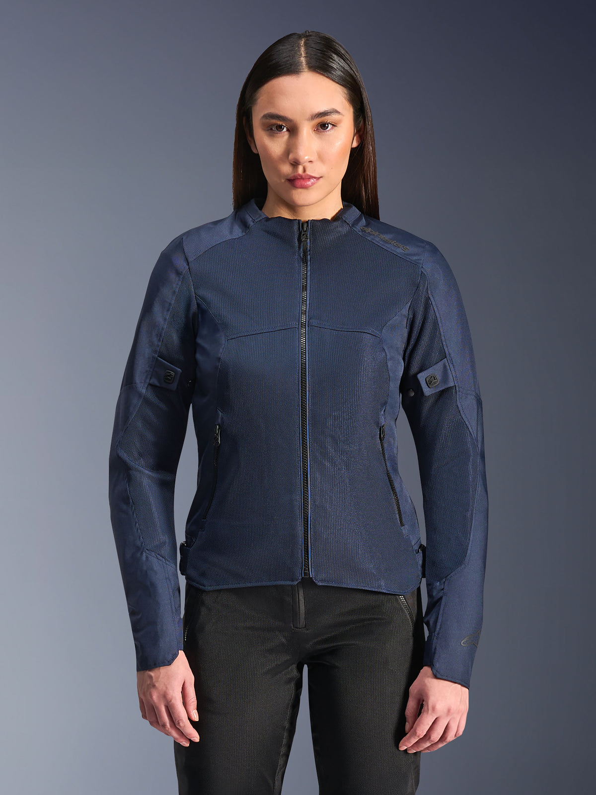 Alpinestars Stella C-1 Air Jacket in blu, giacca da moto da donna, indossata con pantaloni da guida neri, ampi pannelli in rete per il flusso d'aria, tasche frontali e laterali con zip, design moderno e pulito