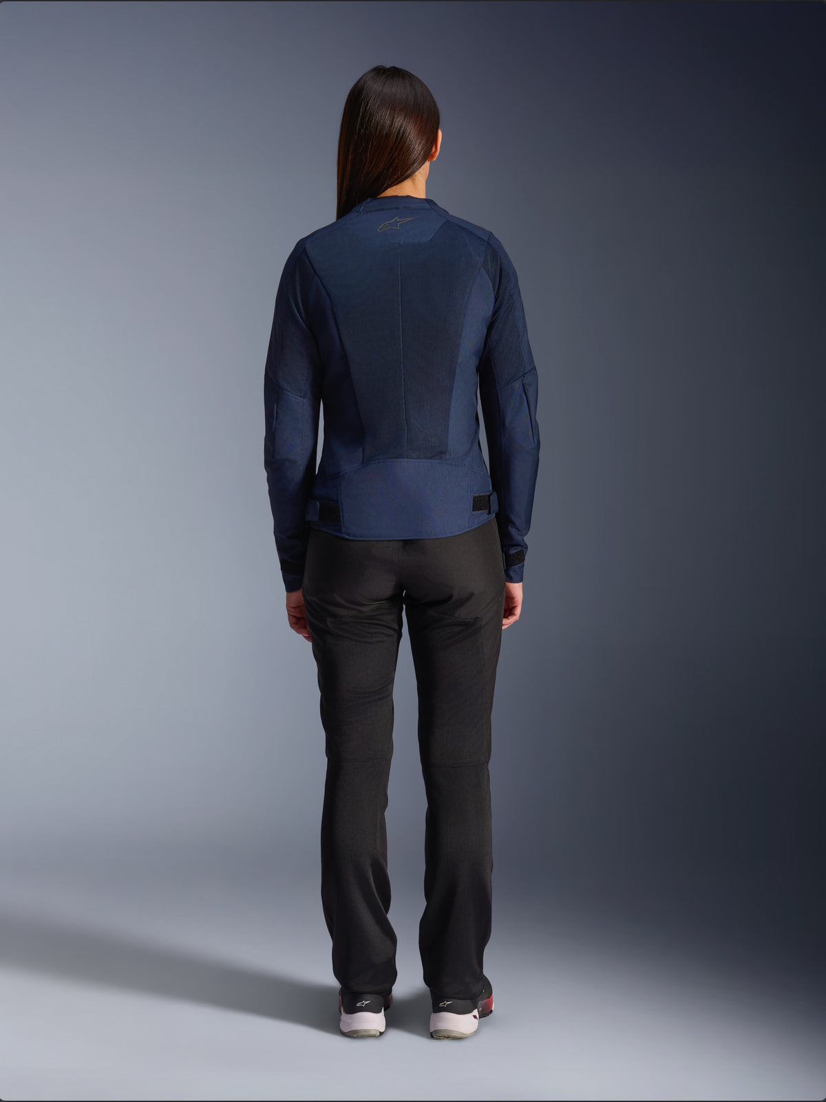 Giacca Alpinestars Stella C-1 Air, giacca da moto in tessuto da donna, blu navy, vista posteriore con ampi pannelli in mesh per la ventilazione e logo Alpinestars sul collo, abbinata a pantaloni da moto neri per un look urbano moderno
