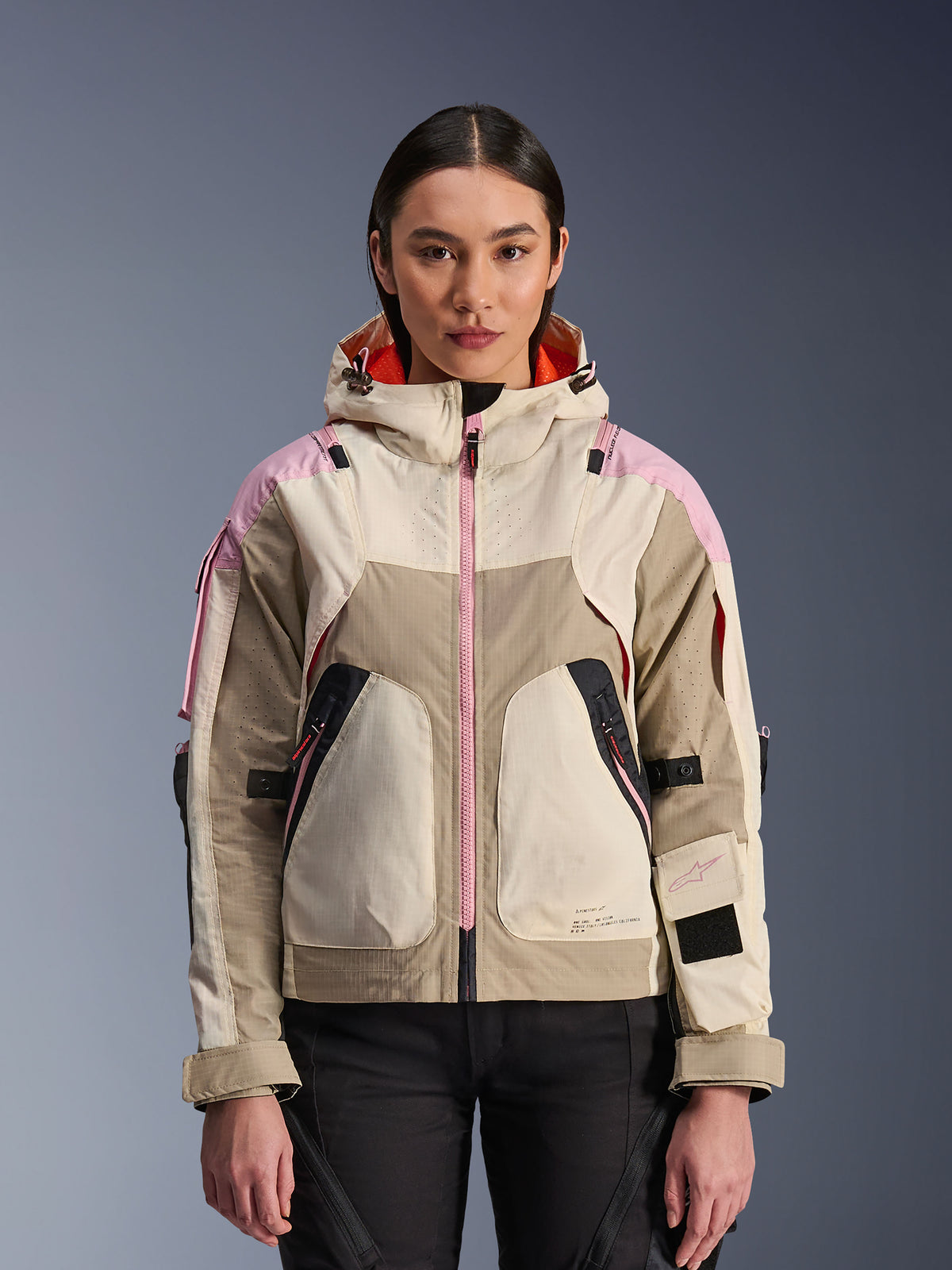 Alpinestars Molly Air Jacket, giacca da moto urbana da donna, colorazione Sand Pink Almond, design con cappuccio e ventilazione laser-perforata, dettaglio zip rosa e cinghie regolabili sulle maniche, indossata da una modella.