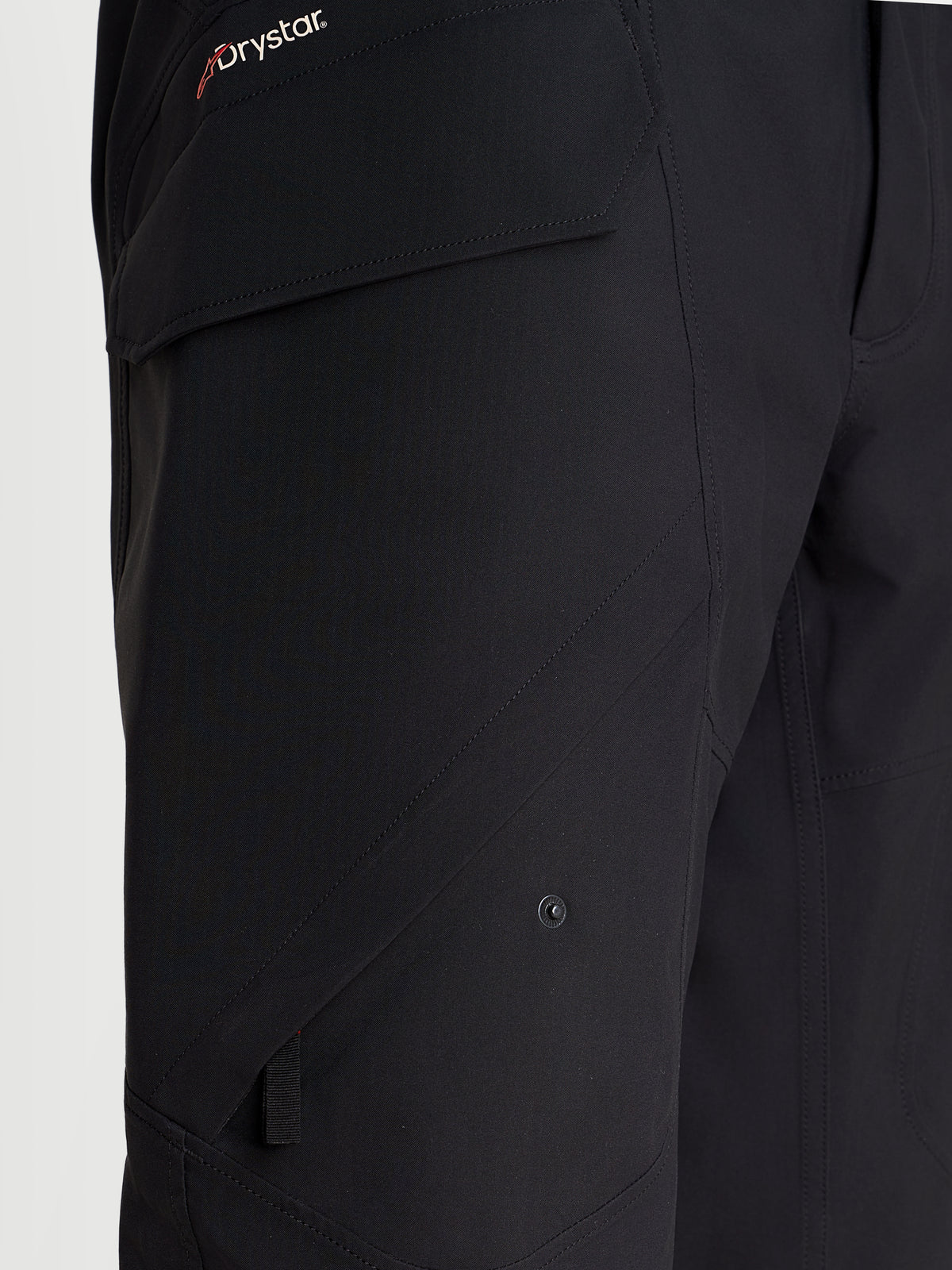 Alpinestars Juggernaut V 2 Drystar Pantaloni, pantaloni da moto urban da uomo, colore nero, vista ravvicinata che evidenzia la tasca cargo laterale e il marchio Drystar