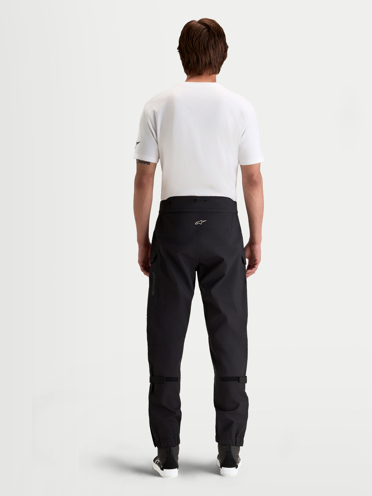 Alpinestars Juggernaut V 2 Drystar Pantaloni, pantaloni da moto urbani impermeabili da uomo, colore nero, vista posteriore con fascia in vita alta e struttura in tessuto tecnico indossati da un modello