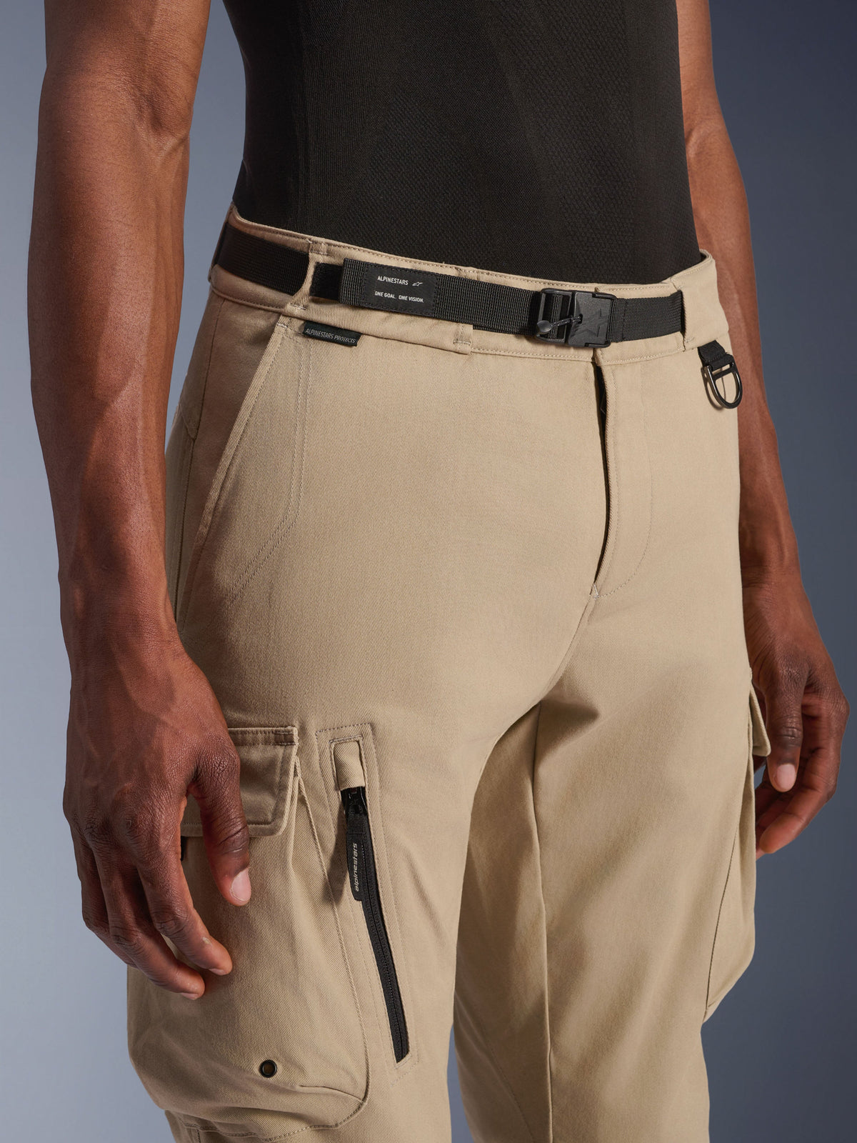 Alpinestars Flex-AST Cargo Pants, pantaloni cargo da moto, beige chiaro, con cintura in tessuto nero integrata con logo, anello a D in metallo, tasca laterale con zip e robusto tessuto twill per un look urbano funzionale