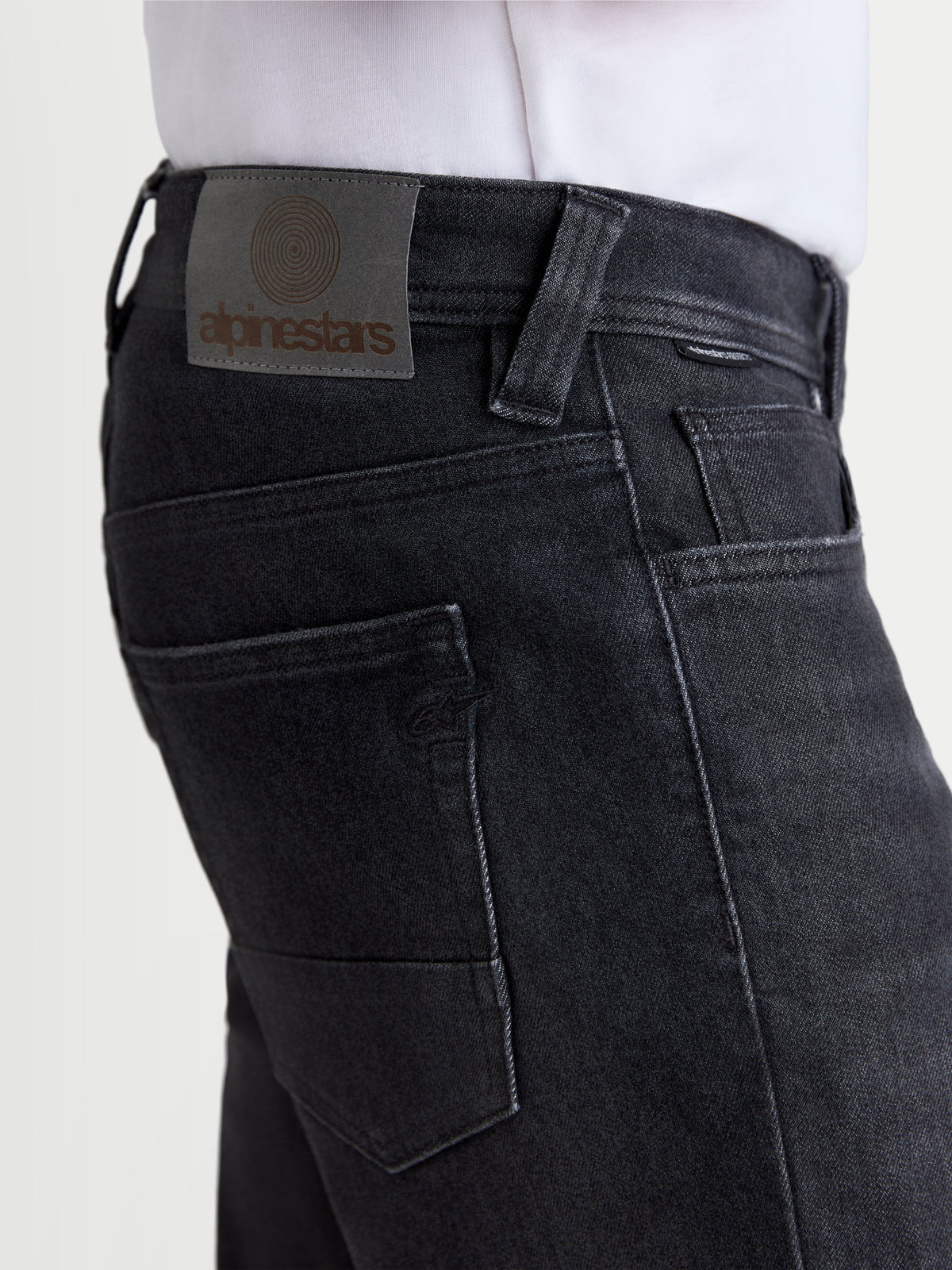 Alpinestars Flex Ast 8 Denim Pantaloni, jeans da moto urbani, colore nero used, vista ravvicinata che evidenzia la Toppa posteriore in pelle e le tasche posteriori indossati da un modello