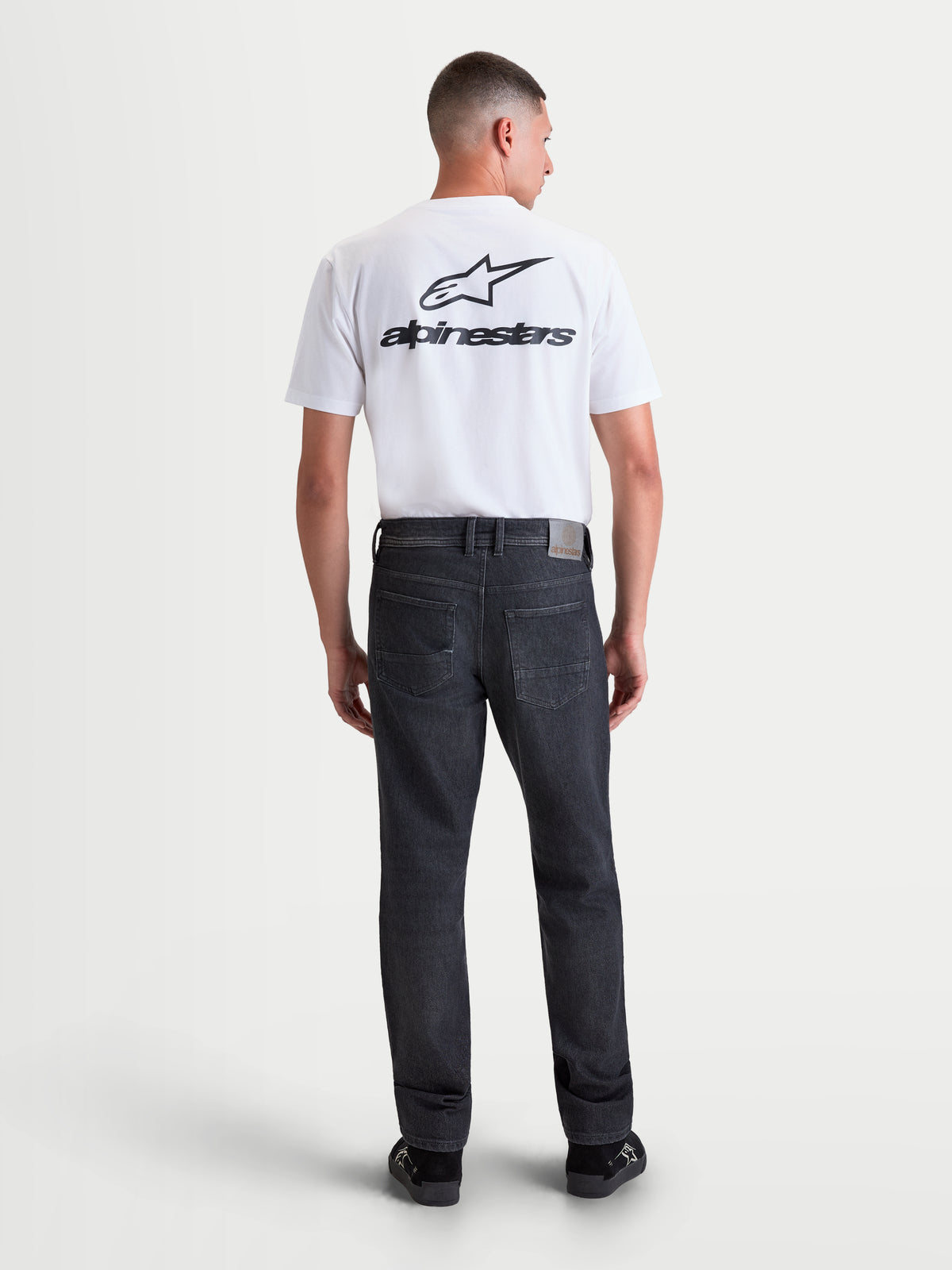 Alpinestars Flex Ast 8 Denim Pantaloni, jeans da moto urbani da uomo, colore nero slavato, vista posteriore su un modello che indossa il denim monostrato con toppa posteriore in pelle e ricamo sulla tasca