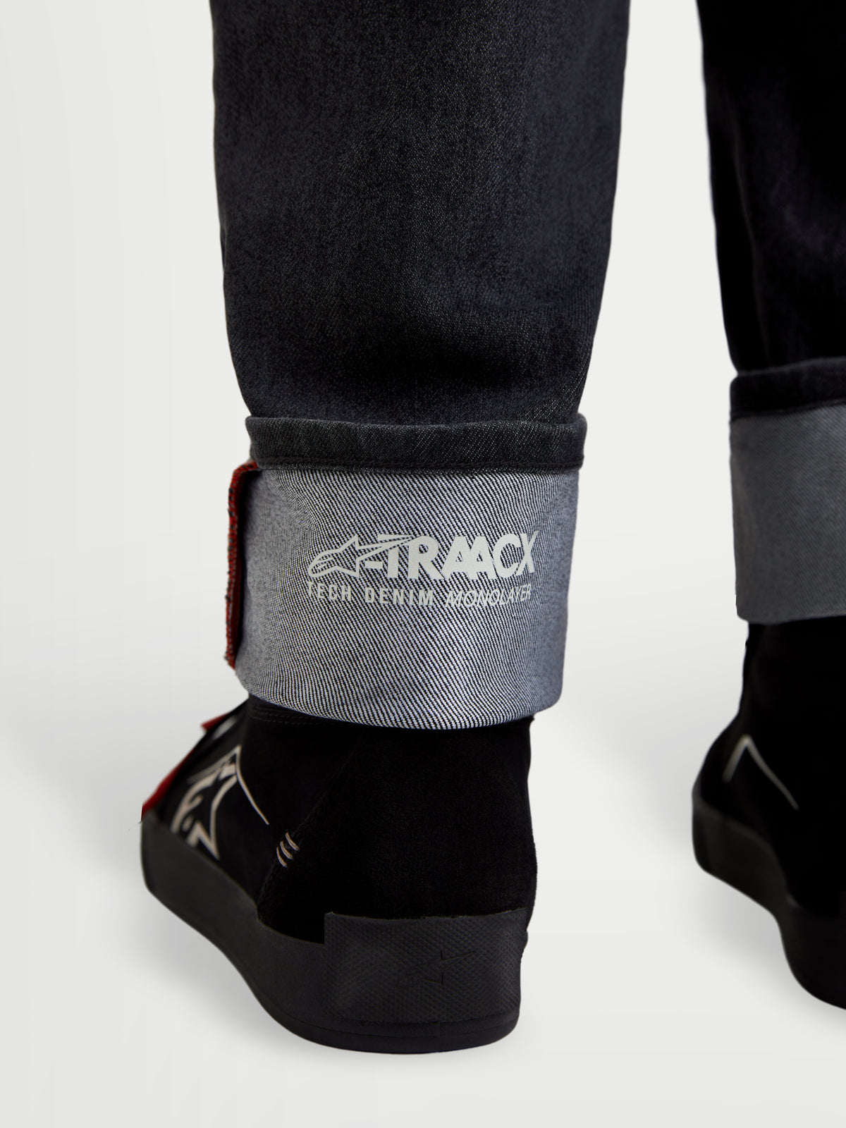 Alpinestars Flex Ast 7 Denim Pantaloni, jeans da moto in denim slavato nero, vista ravvicinata dell'orlo risvoltato con dettaglio del marchio A-TRAACX technical denim e cimosa