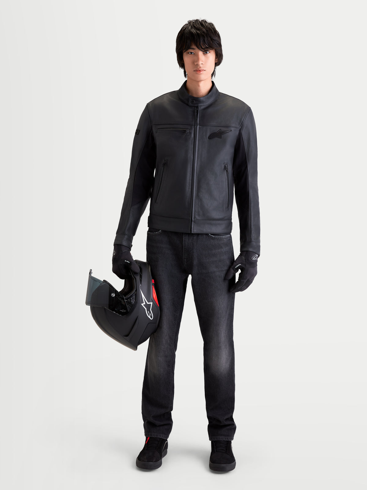 Alpinestars Flex Ast 7 Denim Pantaloni, jeans da moto urbani da uomo in nero slavato, indossati da un modello che tiene un casco e abbigliamento coordinato