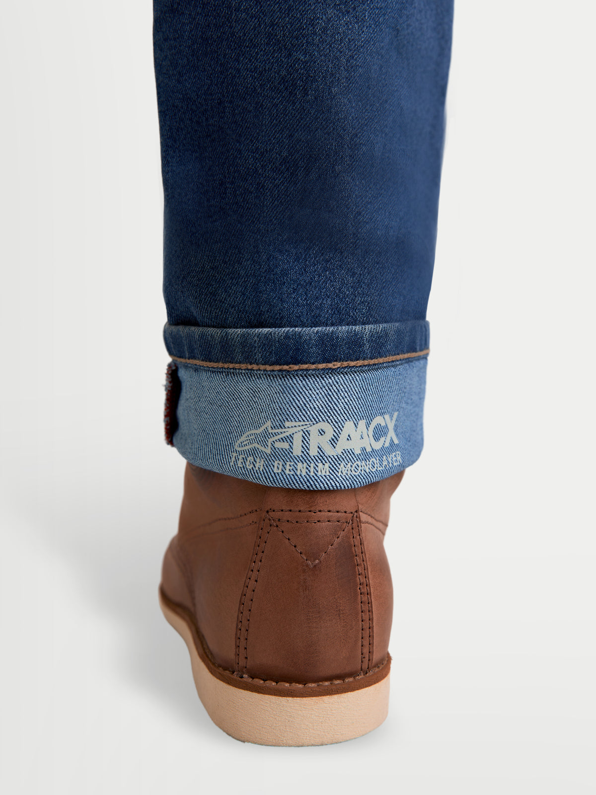 Alpinestars Flex Ast 7 Denim Pantaloni, jeans da moto urbani da uomo, azzurro chiaro, dettaglio del risvolto con marchio A-TRAACX tech denim monolayer e stivali da moto in pelle marrone