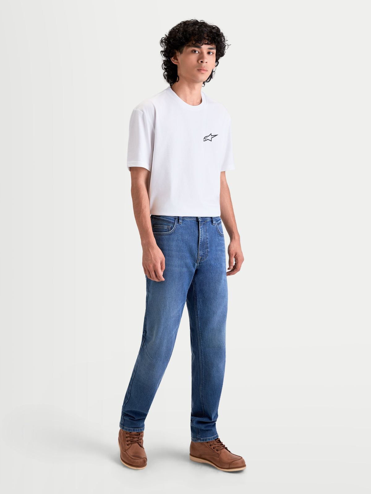 Alpinestars Flex Ast 7 Denim Pantaloni, pantaloni da moto urban da uomo, azzurri, vista frontale completa su un modello che indossa una t-shirt bianca e scarpe marroni, jeans tecnici certificati AA