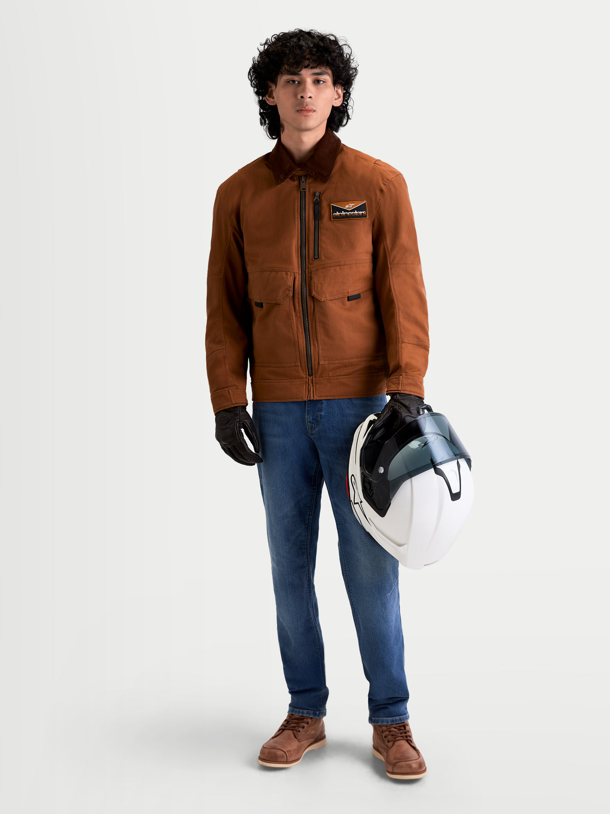 Alpinestars Flex Ast 7 Denim Pantaloni, jeans da moto urbani da uomo in azzurro chiaro, indossati da un modello che tiene un casco e una giacca coordinata