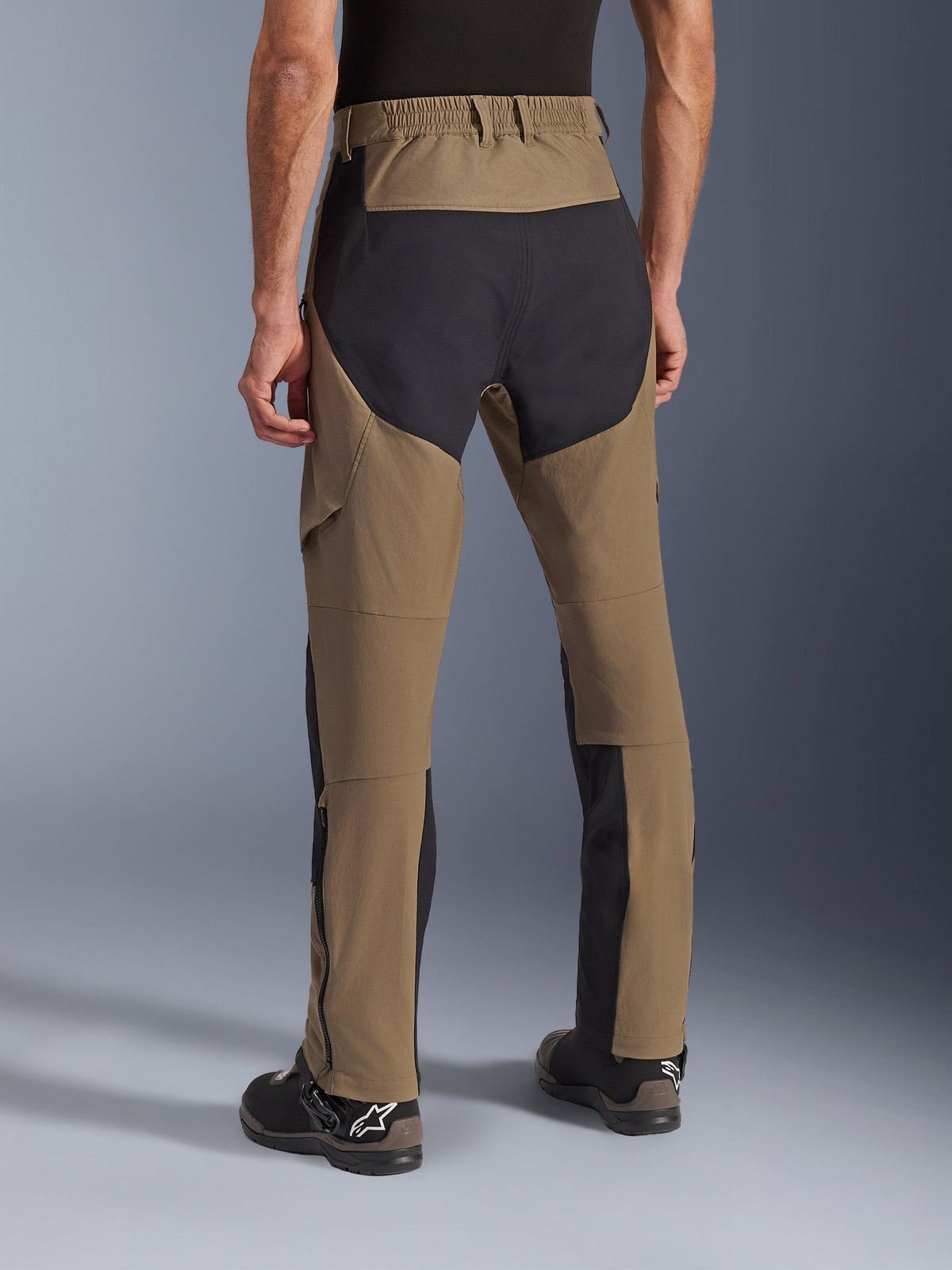 Alpinestars Flex-AST Explorer Pants, pantaloni da moto adventure Walnut Black, vista posteriore che mostra pannelli in ripstop neri sulla seduta e sulle gambe, vita elasticizzata e costruzione in tessuto elasticizzato resistente.