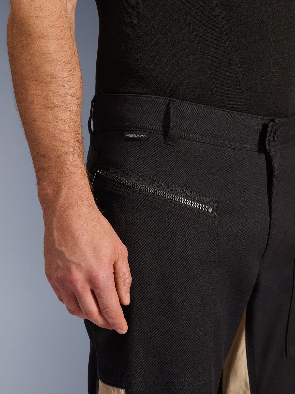 Alpinestars Flex-AST Canvas Pants in Black Aluminum, vista ravvicinata della zona del fianco con tasca orizzontale con zip, passanti per cintura e piccola etichetta del brand, robusta costruzione in policotone elasticizzato per la guida urbana.