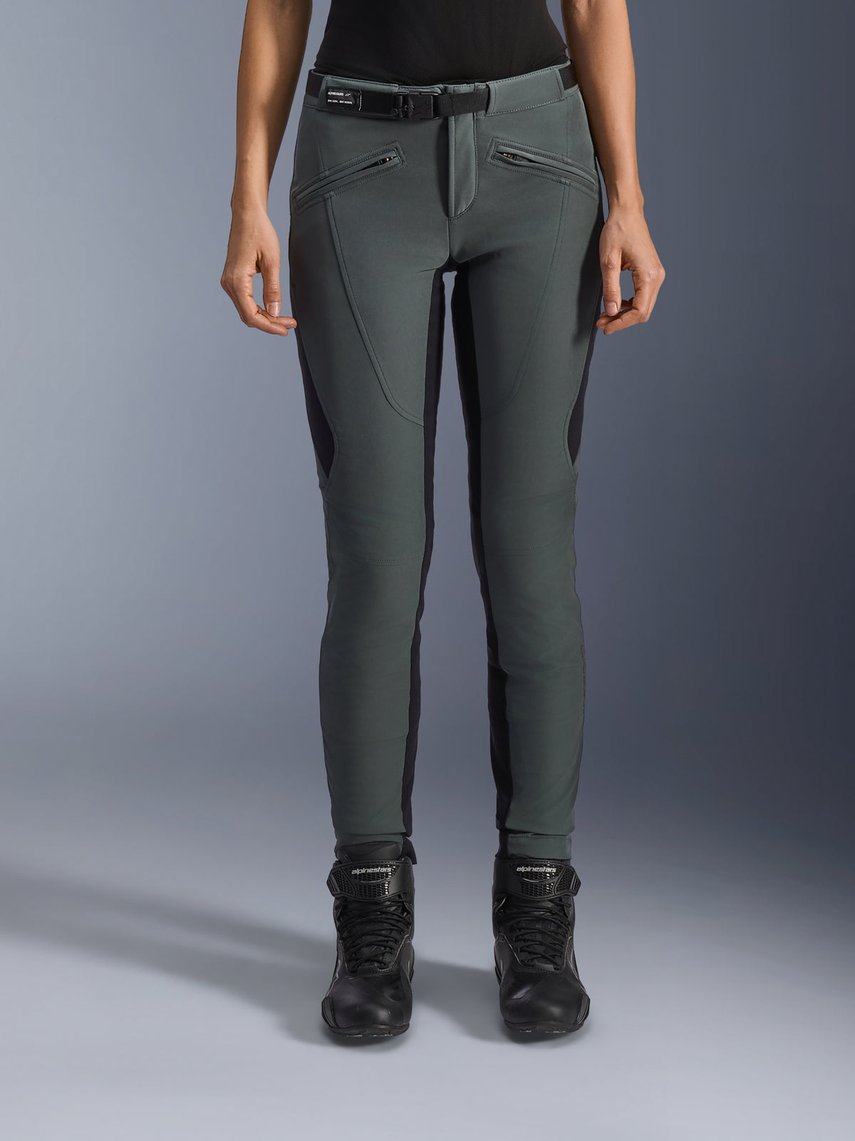 Alpinestars Pantaloni Alamosa, pantaloni da moto urban da donna, grigio urbano e nero, in tessuto softshell slim fit con tasche con zip, indossati con stivali neri