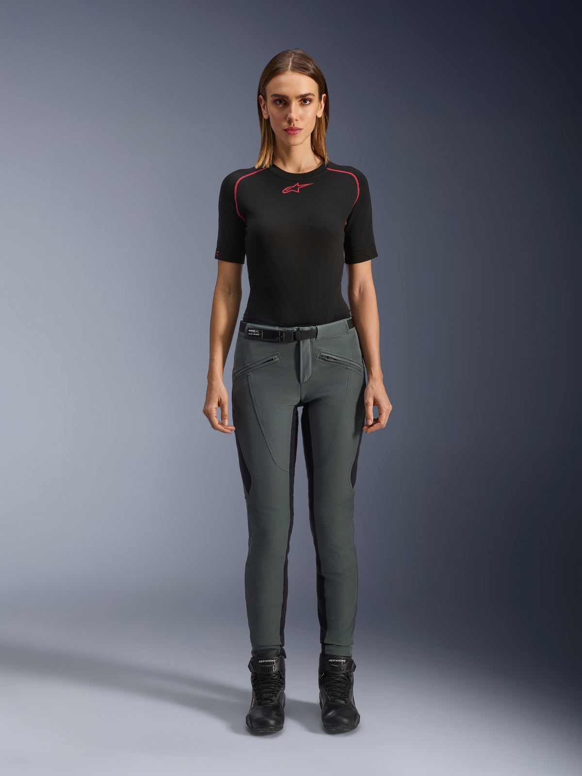 Alpinestars Pantaloni Alamosa, pantaloni da moto slim fit da donna, grigio urbano, in softshell elasticizzato con protezioni CE, indossati con maglia e stivali neri, stile urban streetwear