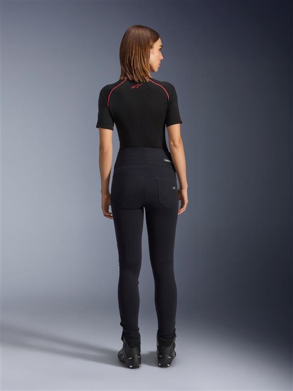 Alpinestars Stella Flex-Ast Leggings, leggings da moto da donna, nero, vista posteriore con vestibilità slim a vita alta, indossati con top nero a maniche corte e stivali da moto neri, abbigliamento urban riding
