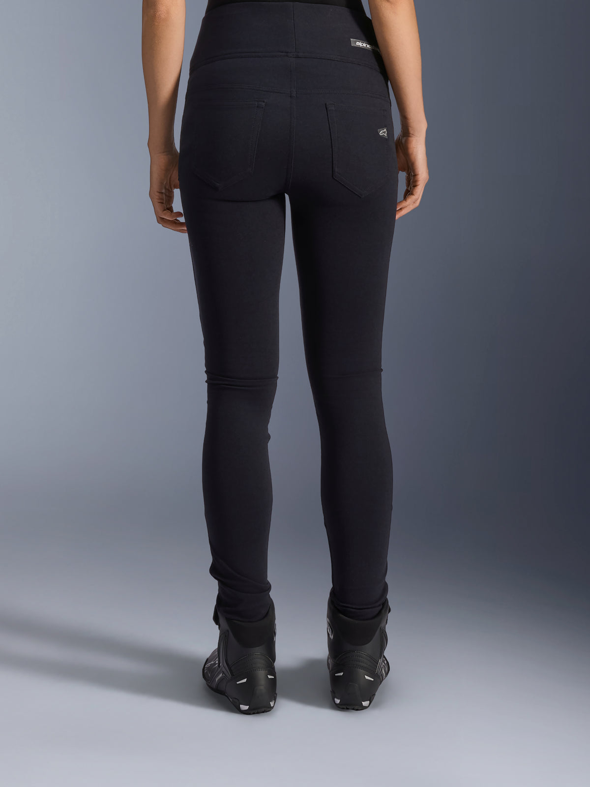 Alpinestars Leggings Stella Flex-Ast, leggings da moto da donna, nero, vista posteriore con tasche posteriori e vestibilità slim, indossati con stivali da moto neri, stile urban riding