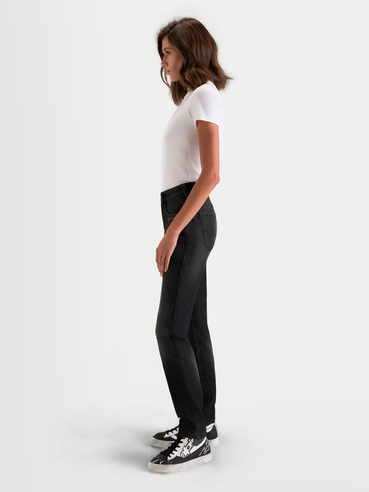 Alpinestars Stella Flex-AST 5 Denim Pants Short, jeans da moto urbani da donna in nero slavato, vista profilo laterale indossati da una modella che mostra la vestibilità slim fit corta e la struttura a strato singolo