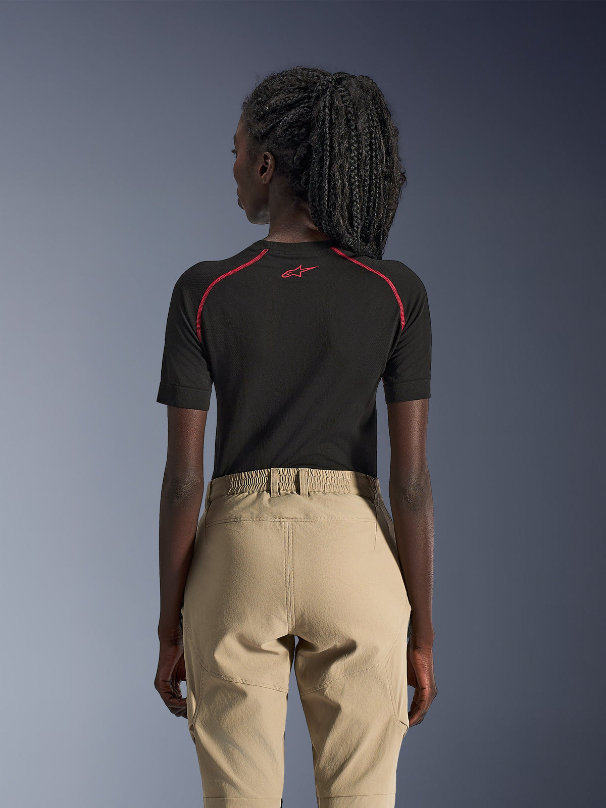 Pantaloni Alpinestars Stella Flex-AST Explorer da donna, color sabbia, pantaloni da moto adventure, vista posteriore, indossati con un base layer nero a maniche corte con accenti rossi, caratterizzati da vita elastica e costruzione in tessuto resistente