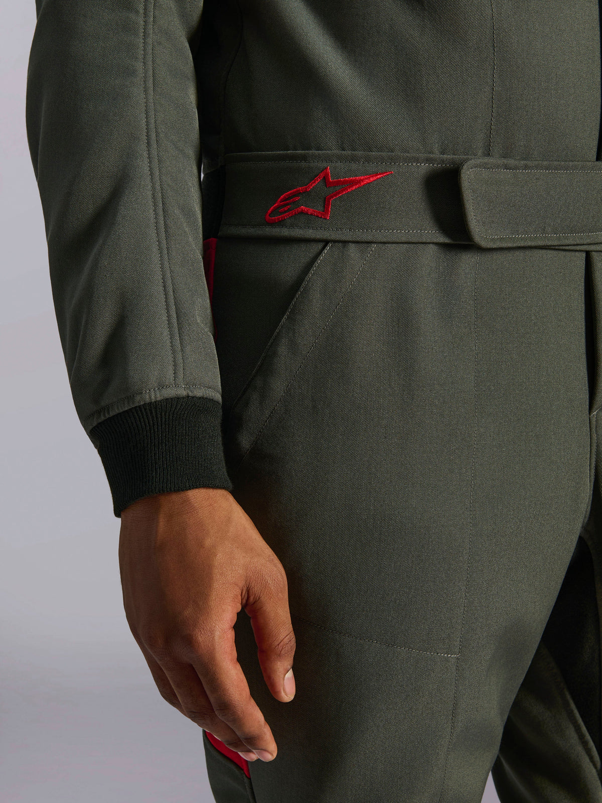 Alpinestars GP Race V3 Suit FIA, tuta da auto, Antracite Rosso, primo piano della cintura regolabile in vita con logo ricamato rosso e polsino della manica a coste nero su tessuto twill testurizzato