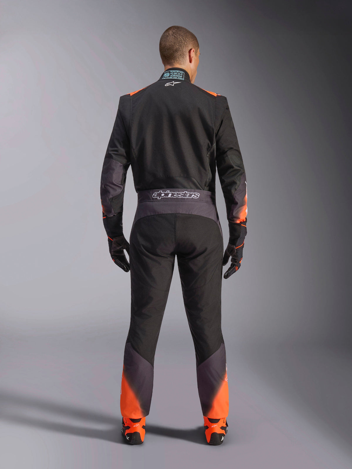 Alpinestars tuta KMX-5 V3, tuta da kart intera uomo, nera e arancione fluo, certificata FIA, vista posteriore con marchio