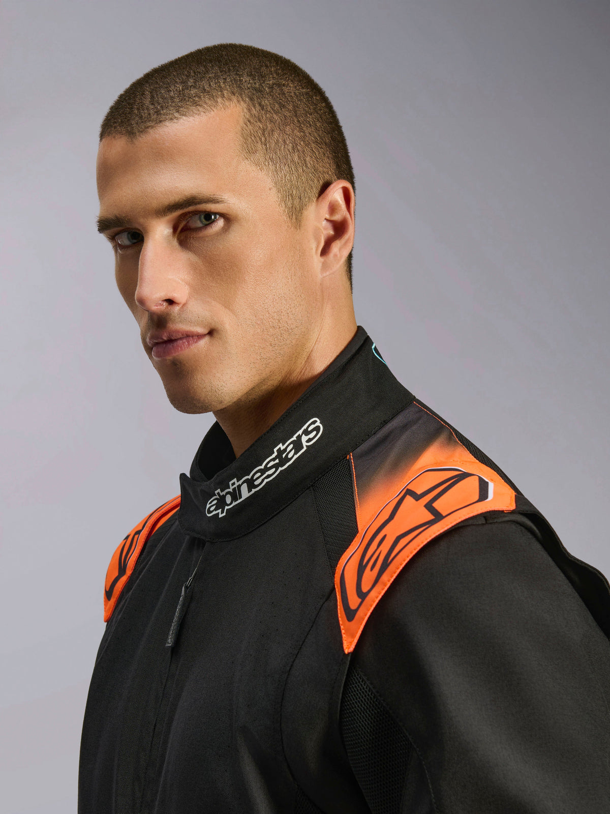 Alpinestars Tuta KMX-5 V3, tuta da karting da uomo, nero e arancione fluo, certificata FIA, dettaglio colletto e spalle.