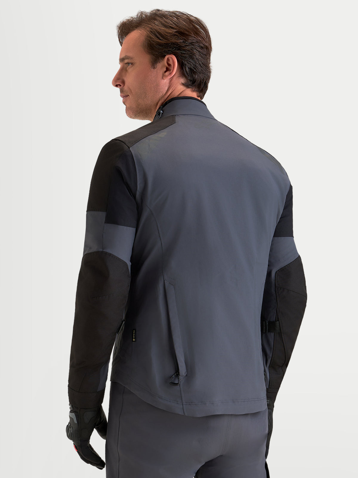 Alpinestars Arenis Gore-Tex Giacca, giacca da moto adventure da uomo in grigio scuro e nero, vista del profilo posteriore che mostra la struttura impermeabile e il colletto ergonomico