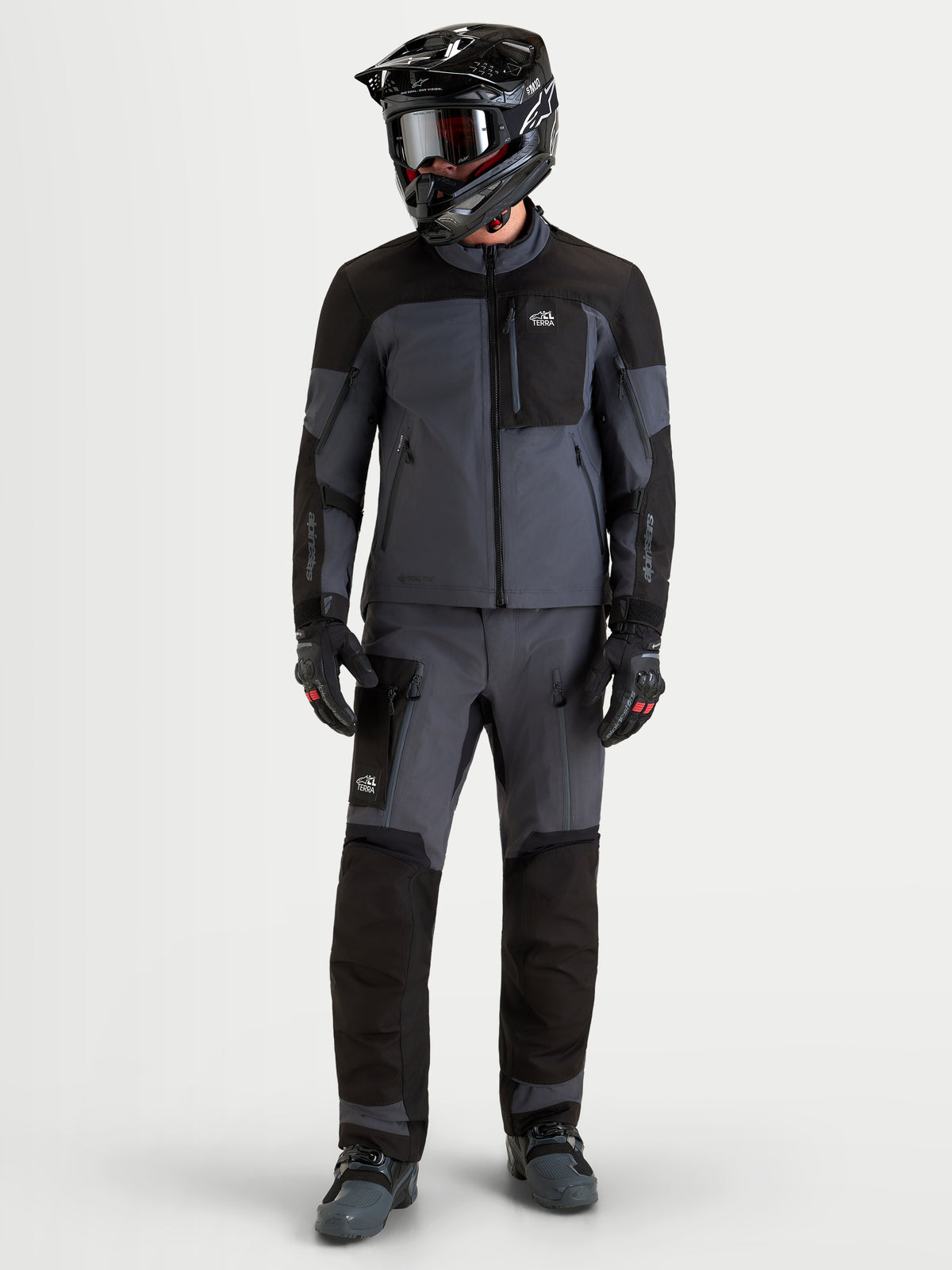 Alpinestars Arenis Gore-Tex® Gear Set, completo da moto adventure da uomo in nero e grigio scuro, vista frontale in studio su modello con equipaggiamento coordinato e casco