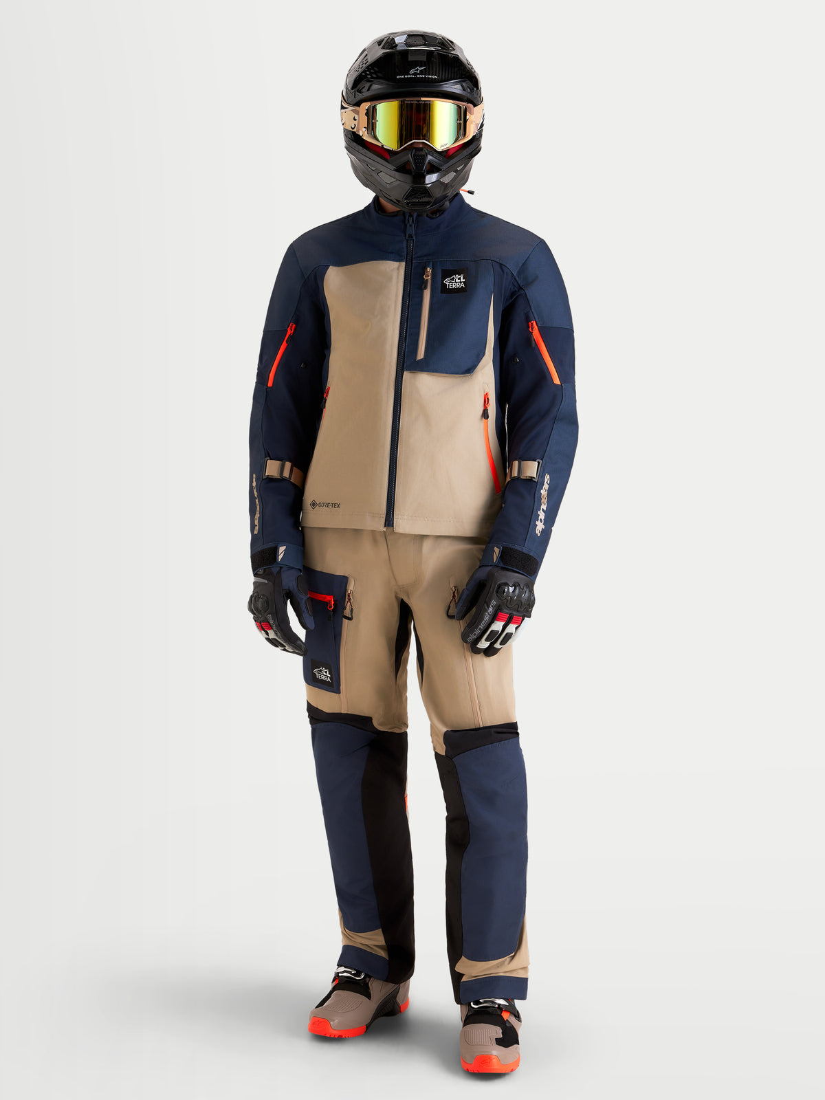 Alpinestars Arenis Gore-Tex Giacca, giacca da moto adventure da uomo in blu notte e beige alluminio, indossata da un pilota con equipaggiamento ADV coordinato e casco