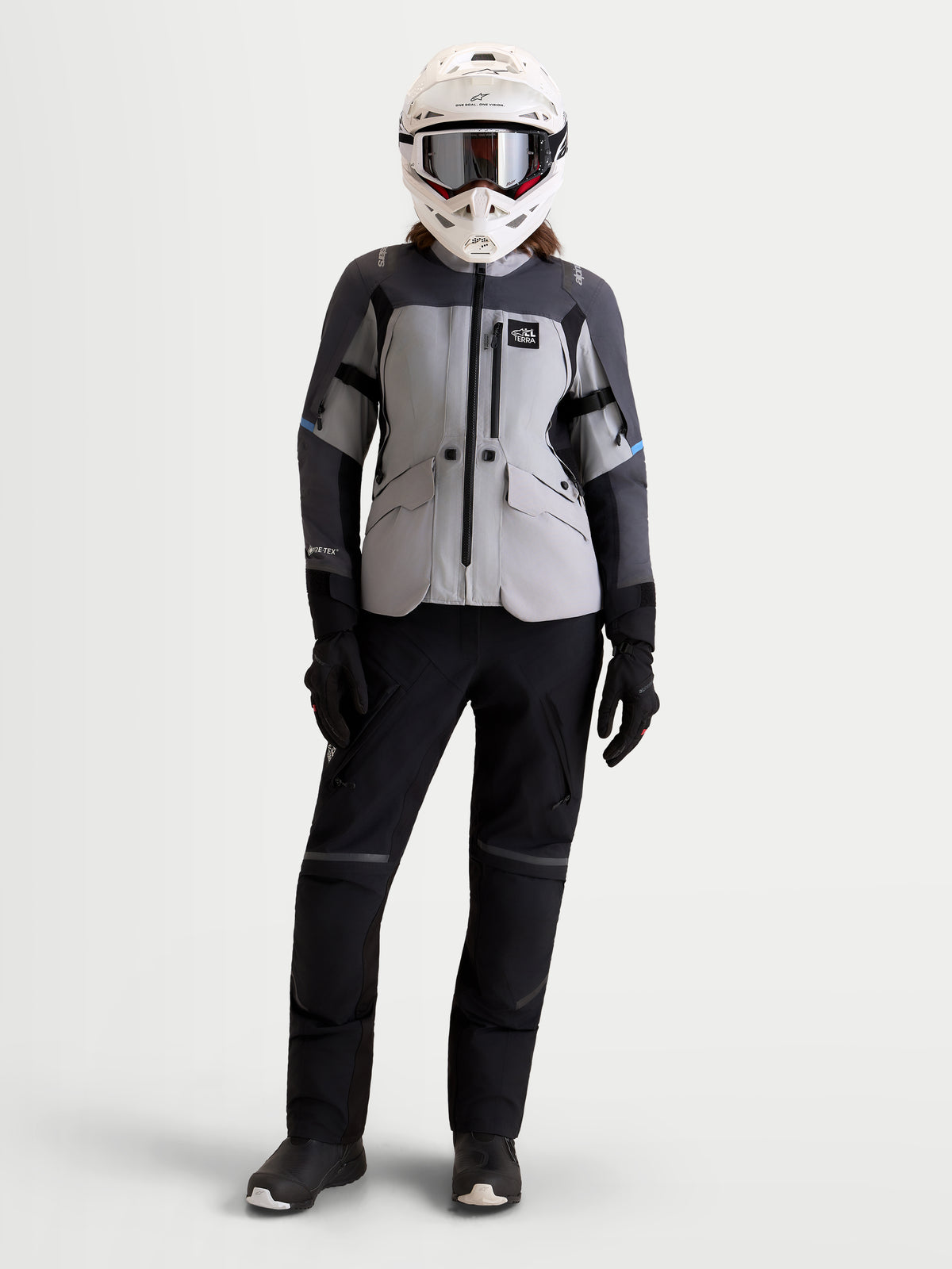 Alpinestars Stella ST-7 V2 2L Gore-Tex Giacca, giacca da moto adventure da donna in grigio medio, grigio scuro e nero, vista frontale a figura intera indossata da una modella con casco e pantaloni coordinati