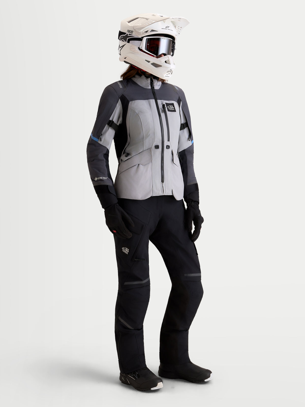 Alpinestars Stella ST-7 V2 2L Gore-Tex Giacca, giacca da moto adventure da donna in grigio medio, grigio scuro e nero, vista frontale in studio su una modella con pantaloni, guanti e casco abbinati