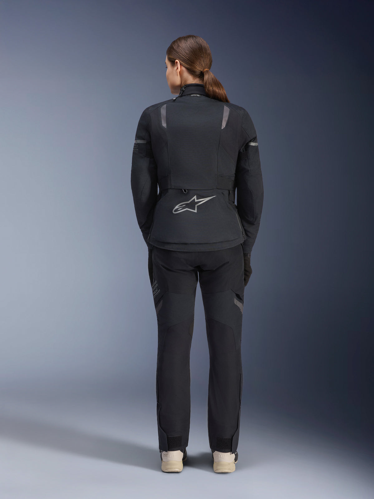 Giacca e pantaloni Alpinestars Stella ST-7 2L GORE-TEX, completo da moto donna per turismo d'avventura, nero e grigio scuro, vista posteriore con logo Astar e dettagli riflettenti, robusta struttura in tessuto impermeabile