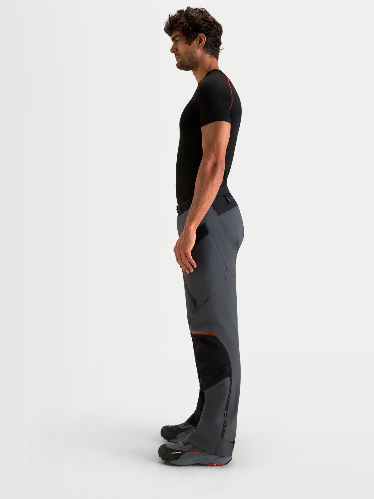 Alpinestars St-7 V2 2L Gore-Tex Pantaloni, pantaloni da moto adventure da uomo, grigio scuro e nero, vista laterale su un modello che mostra la costruzione in tessuto impermeabile e i pannelli ergonomici sulle ginocchia