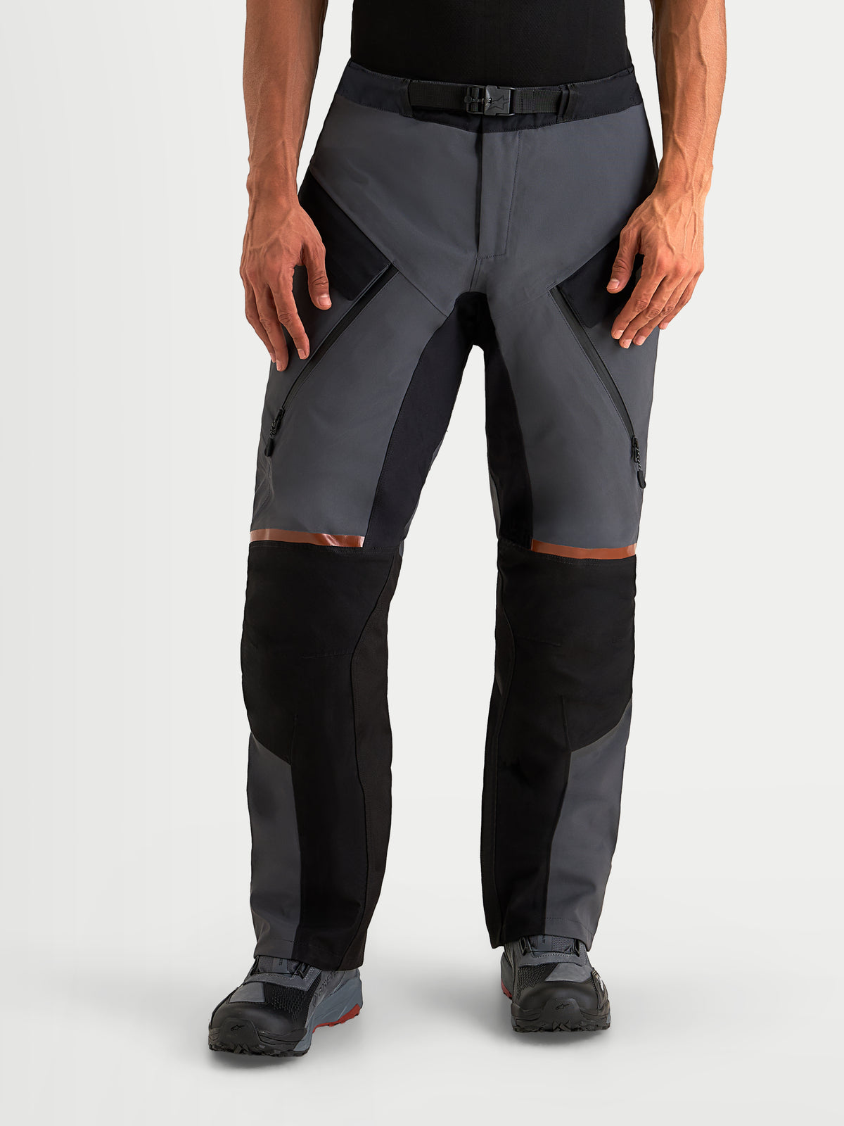 Alpinestars ST-7 V2 2L Gore-Tex Pantaloni, pantaloni da moto adventure da uomo in grigio scuro e nero, vista frontale su un modello che mostra la struttura in tessuto impermeabile, le cerniere di ventilazione sulle cosce e la certificazione CE AA