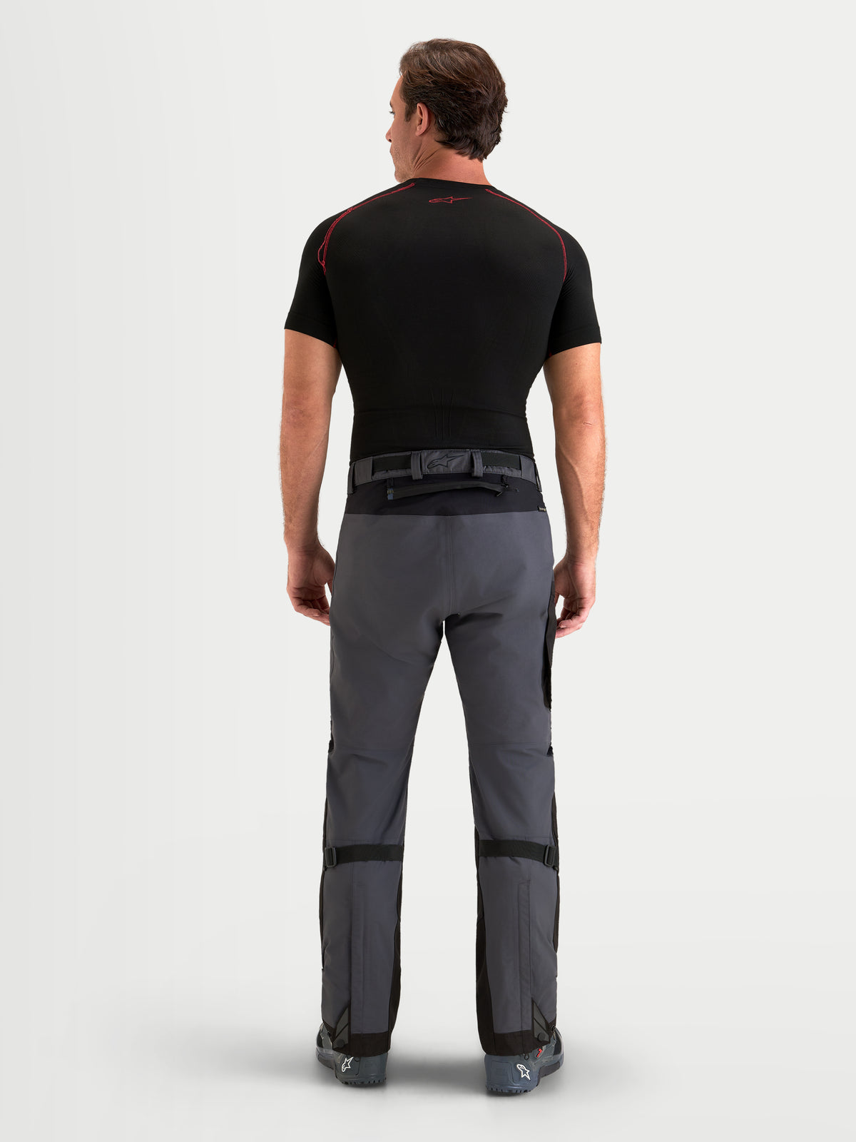 Alpinestars Arenis Gore-Tex Pantaloni, pantaloni da moto adventure da uomo, grigio scuro e nero, vista posteriore su un modello che mostra la struttura in tessuto impermeabile e la chiusura in vita
