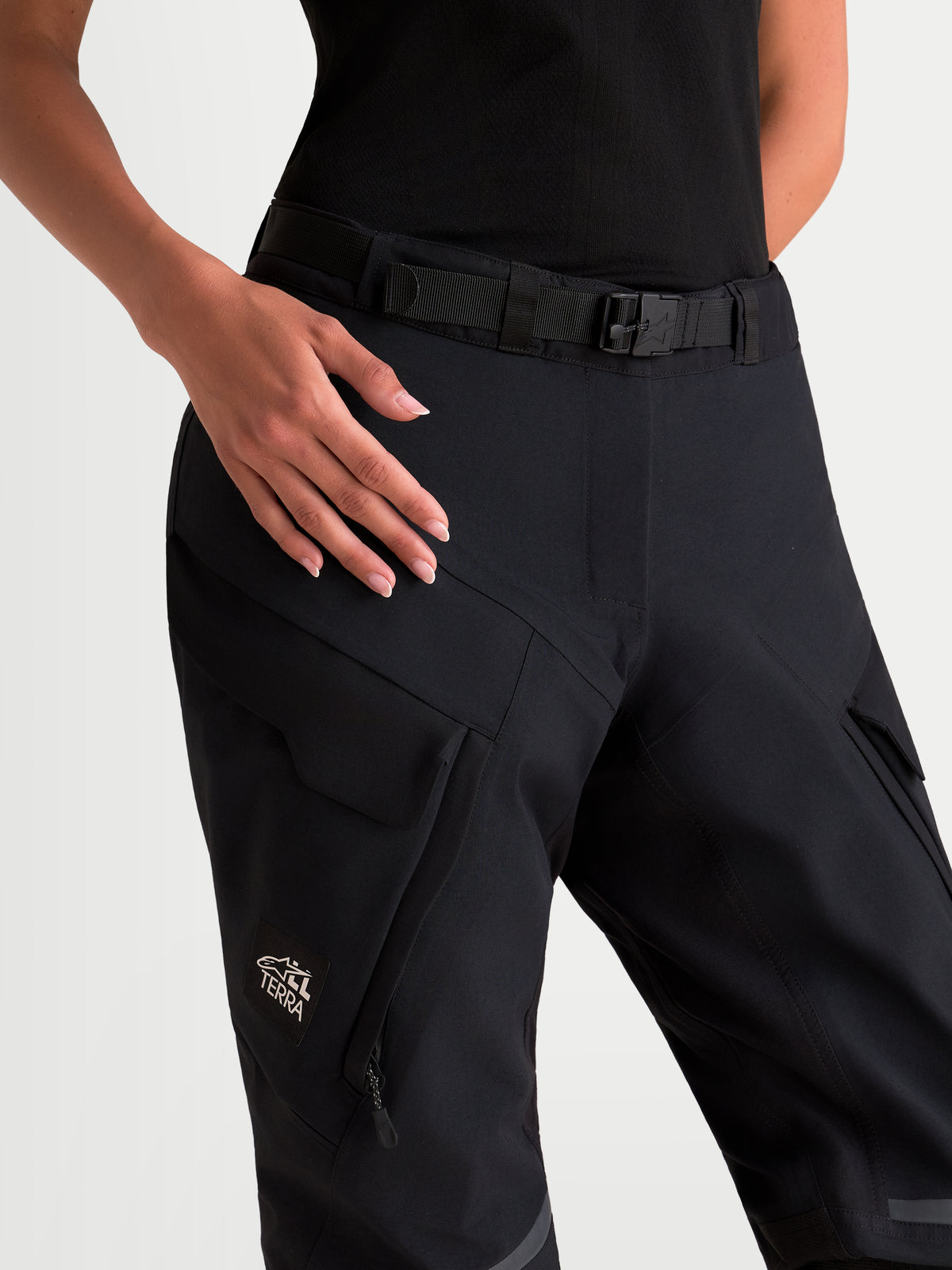 Alpinestars Stella St 7 V 2 2 L Gore Tex Pantaloni, pantaloni da moto adventure da donna, colore nero, vista ravvicinata che mostra la chiusura magnetica in vita, la cintura integrata e le tasche cargo impermeabili indossati da una modella