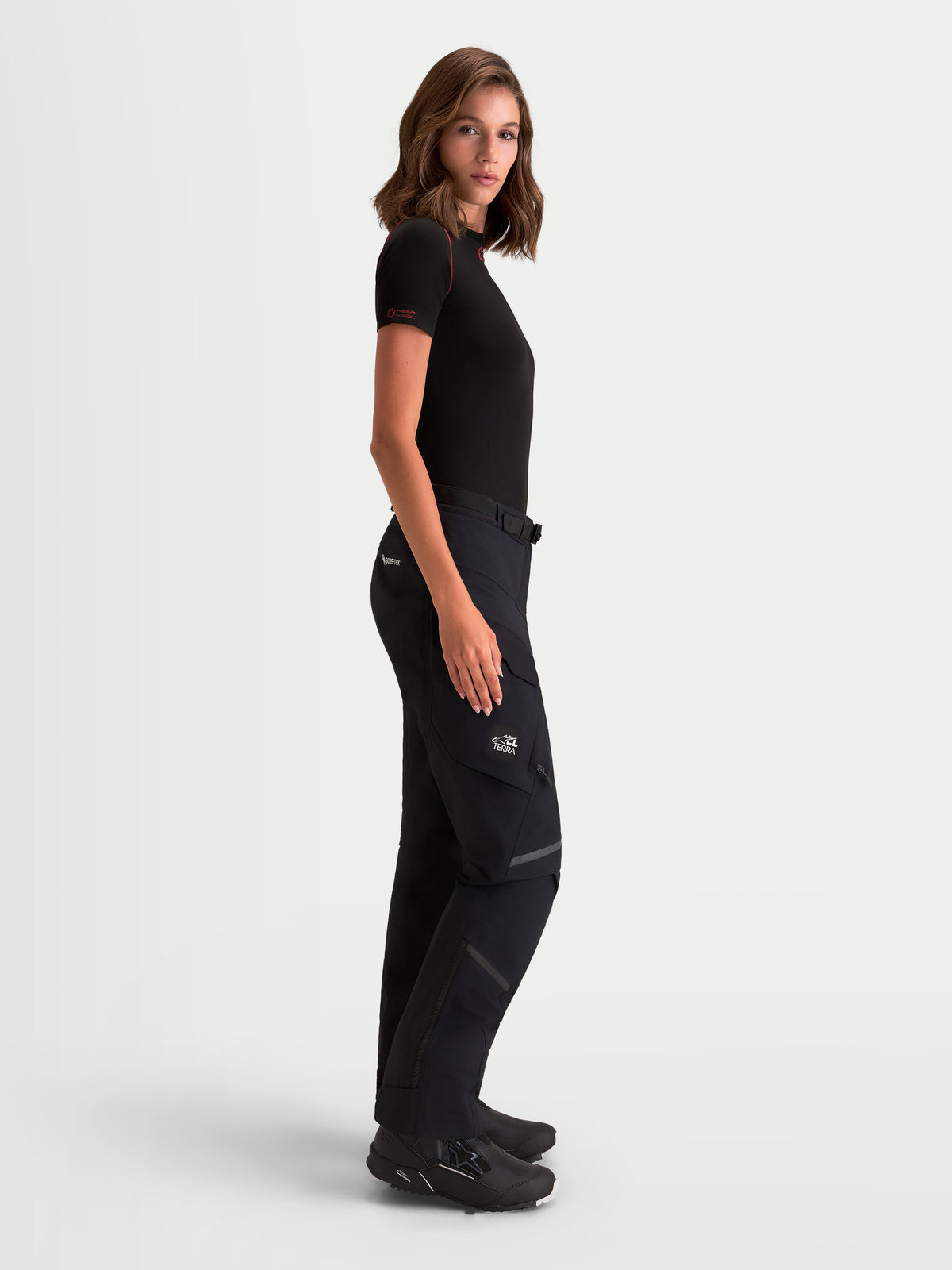 Alpinestars Stella St-7 V2 2L Gore-Tex Pantaloni, pantaloni da moto adventure da donna, colore nero, vista laterale indossati da una modella, con struttura impermeabile GORE-TEX e tasche cargo