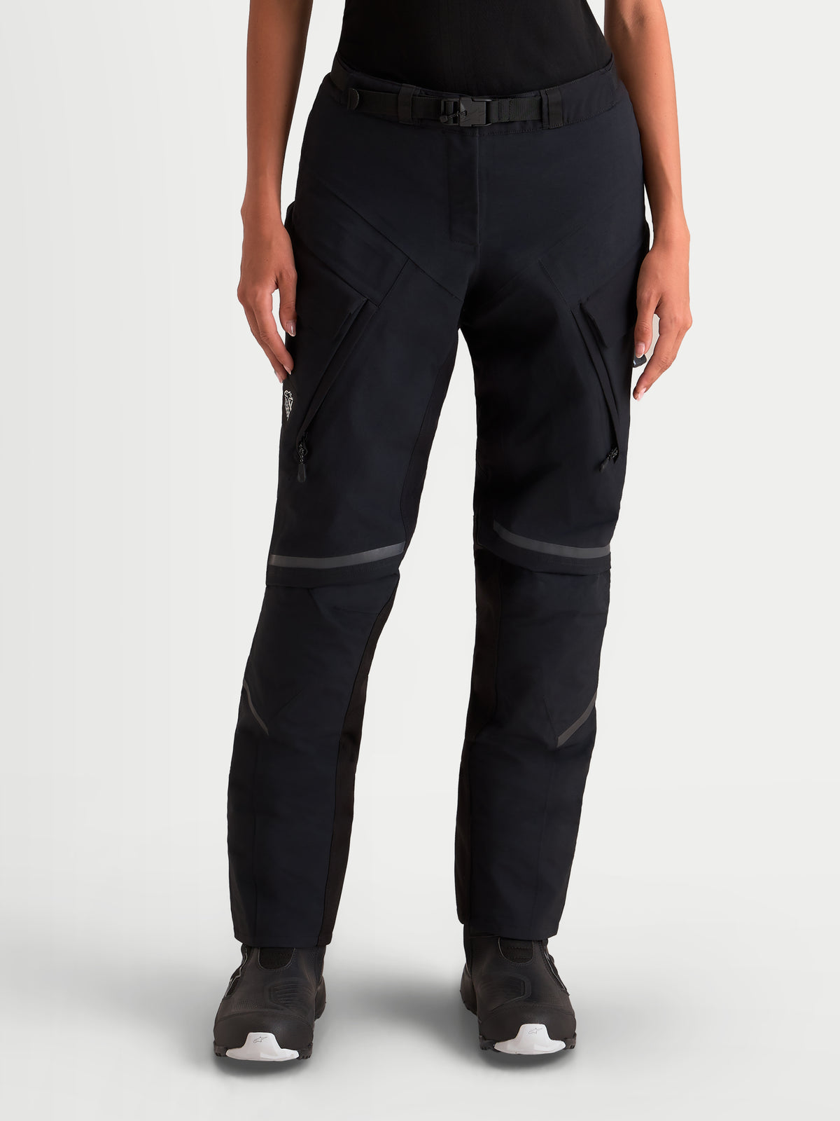 Alpinestars Stella St-7 V2 2L Gore-Tex Pantaloni Short, pantaloni da moto adventure da donna, colore nero, vista frontale con modella che indossa abbigliamento impermeabile con tasche cargo e fibbia magnetica in vita