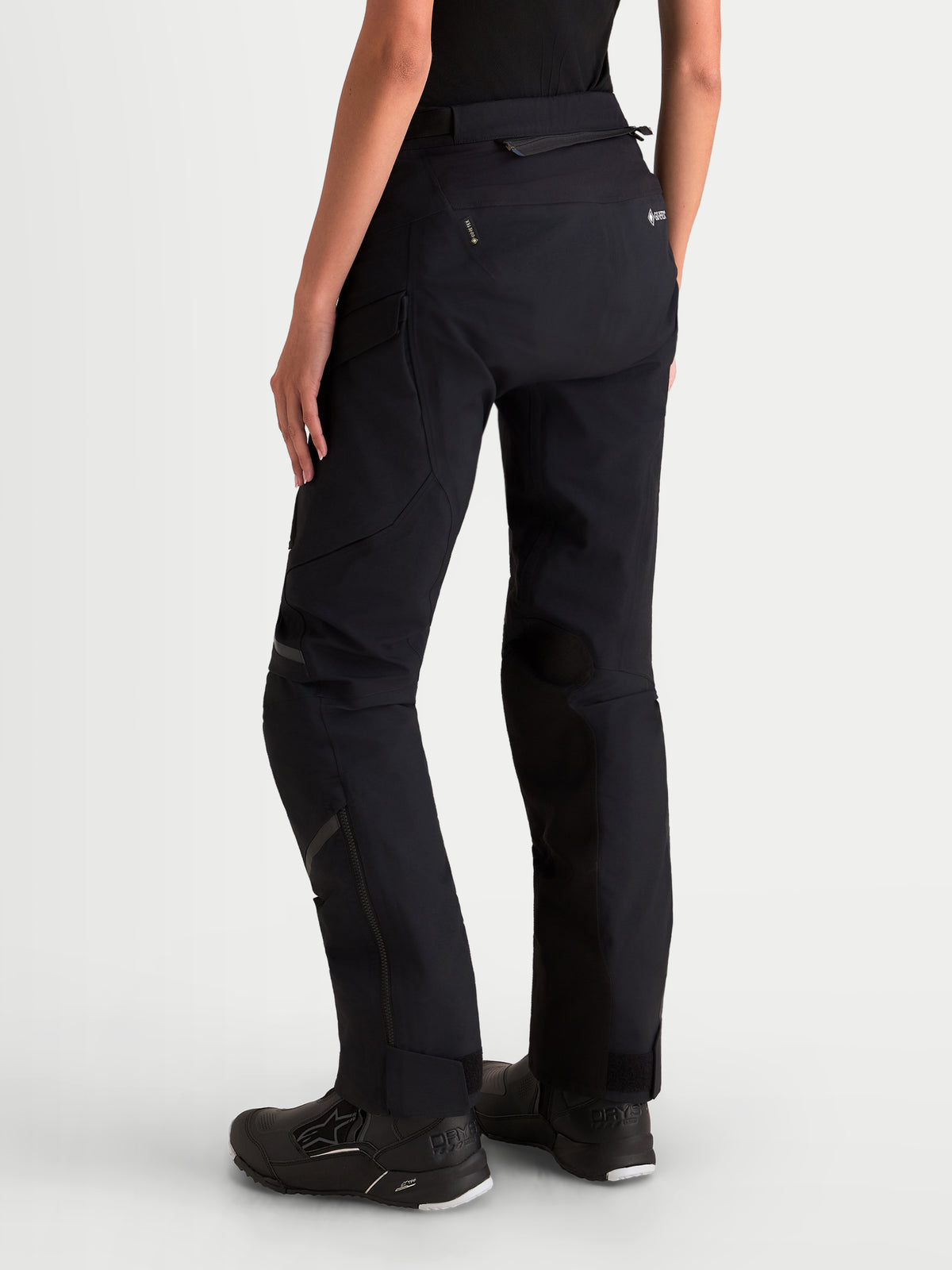 Alpinestars Stella St 7 V 2 2 L Gore Tex Pantaloni, pantaloni da moto adventure da donna, colore nero, vista posteriore su una modella con abbigliamento tecnico impermeabile