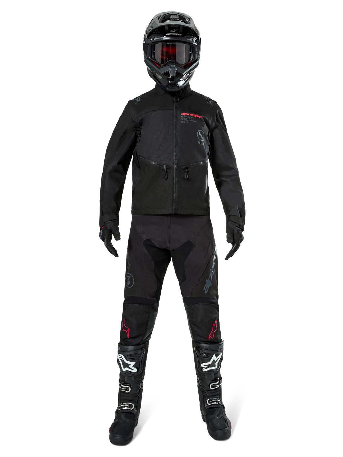 Giacca Alpinestars Pro-Dura, giacca nera da enduro off-road, mostrata su un modello con un set completo di attrezzatura che include casco nero con maschera rossa, pantaloni neri con dettagli rossi, stivali neri e bianchi e guanti neri, design robusto ispirato al rally per trail riding