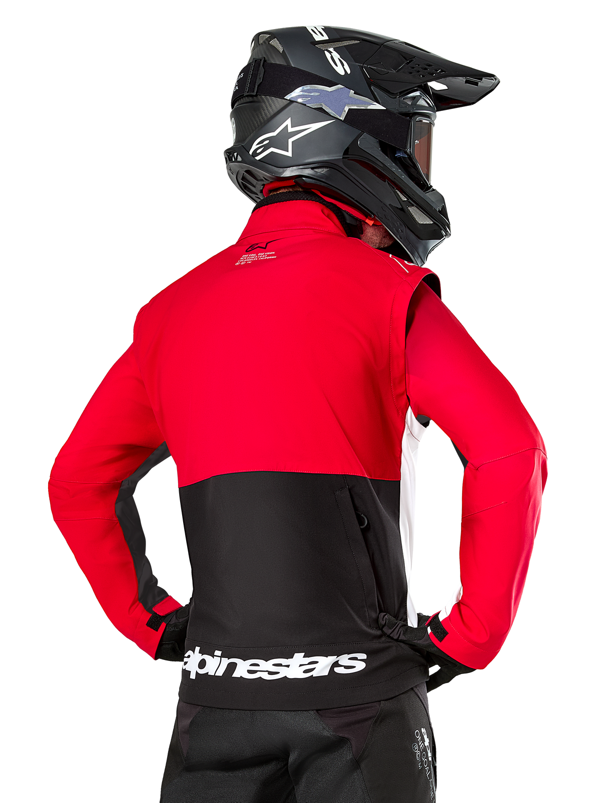 Giacca Alpinestars Pro-Dura, giacca da enduro fuoristrada, rossa e nera con logo Alpinestars bianco sull'orlo posteriore, indossata da un pilota visto da dietro con un casco da motocross nero, design ispirato al rally per una guida aggressiva su sentieri
