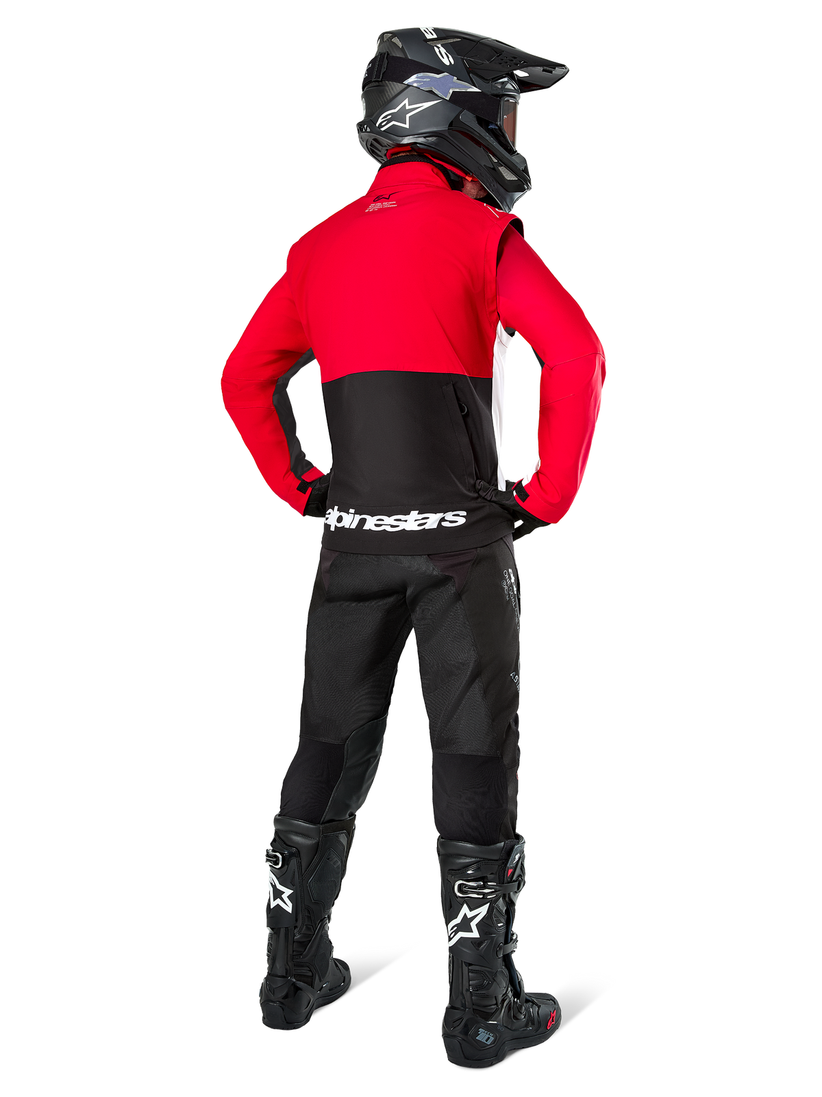 Pilota di motocross visto da dietro che indossa la Giacca Alpinestars Pro-Dura in nero, rosso acceso e bianco, abbinata a pantaloni neri, casco nero e stivali da fuoristrada neri, caratterizzata da una parte superiore rossa e una inferiore nera con logo Alpinestars bianco sulla schiena.
