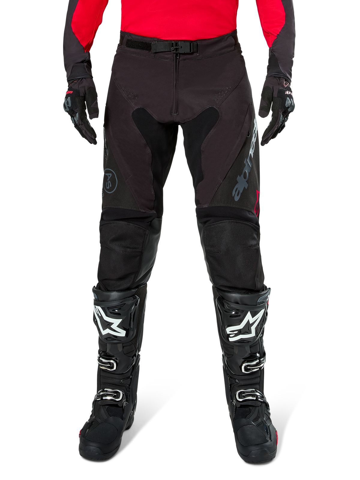 Pantaloni Alpinestars Pro-Dura, pantaloni da enduro neri e magnet, indossati con una maglia rossa a maniche lunghe e stivali da motocross neri, caratterizzati dal marchio Alpinestars grigio e dalla robusta costruzione in ripstop per la guida fuori strada