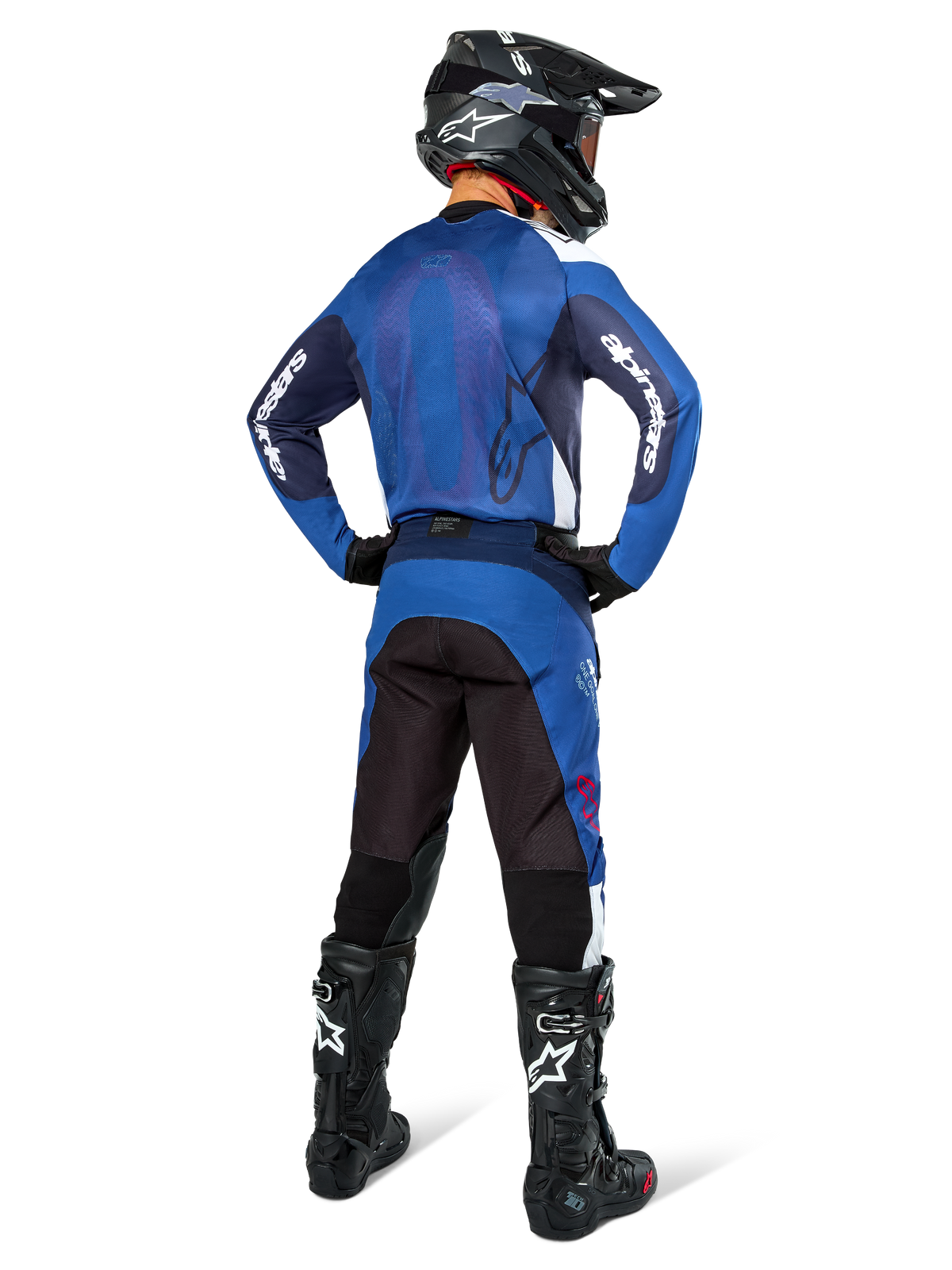 Alpinestars Pro-Dura Pants, pantaloni da motocross ed enduro, blu navy, azzurro e bianco, vista posteriore, indossati con maglia blu coordinata, casco nero e stivali Tech neri, costruzione robusta con inserti elastici per la guida off-road