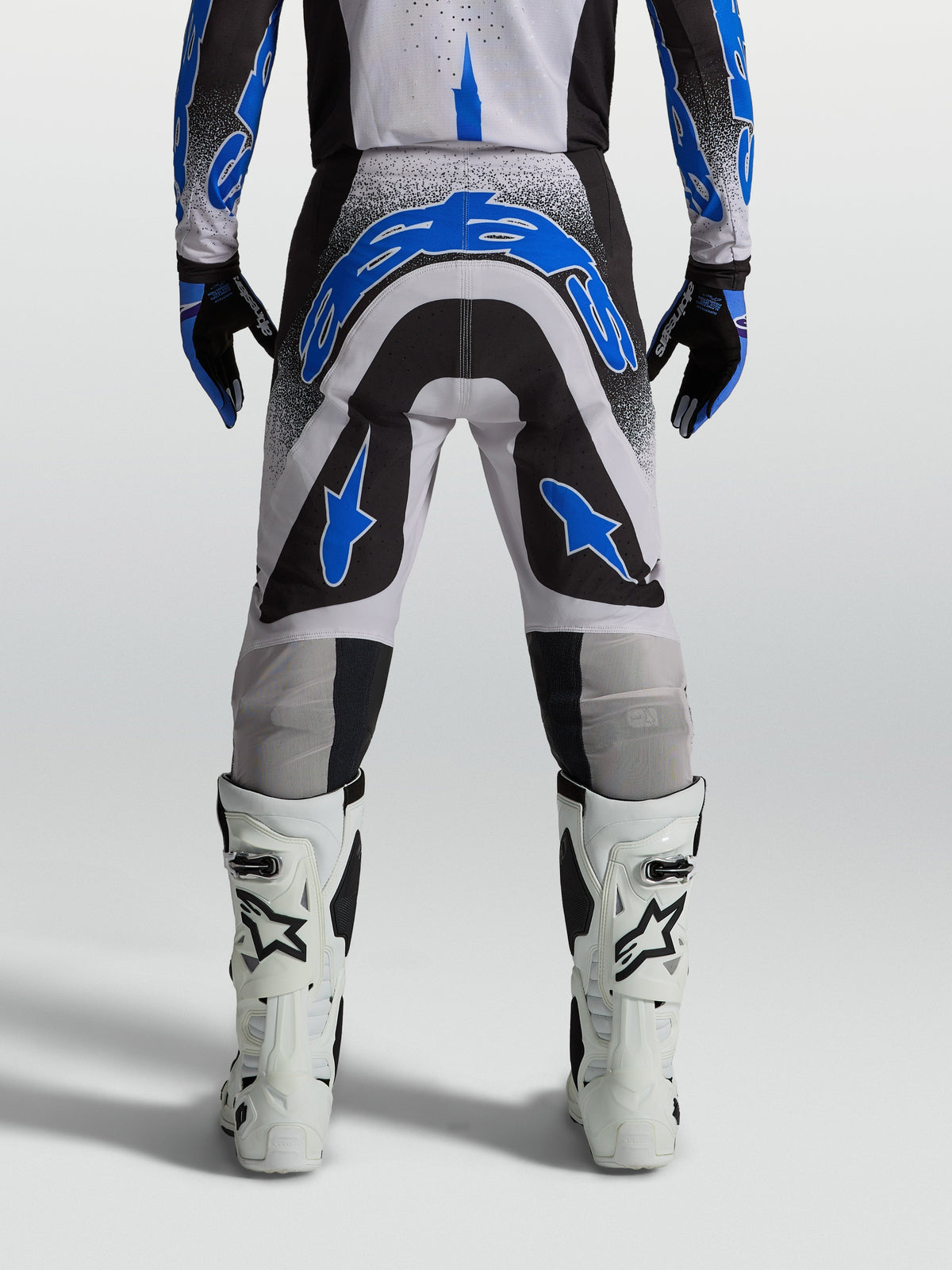 Alpinestars pantaloni Supertech Hiten AFD, pantaloni da motocross uomo, neri e blu, vista posteriore con stivali bianchi