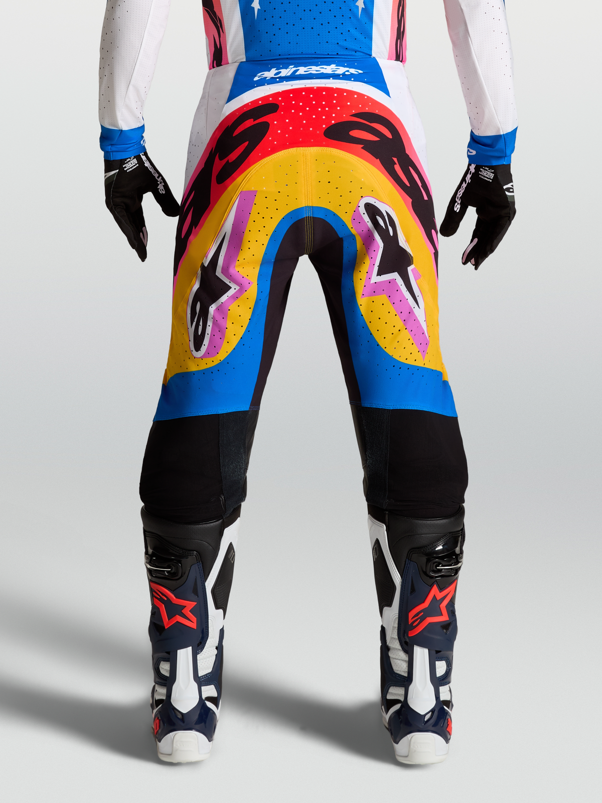 Alpinestars Pantaloni Supertech Dyna, pantaloni da motocross racing, design multicolore blu e giallo, materiale rip-stop elasticizzato leggero, indossati da modella