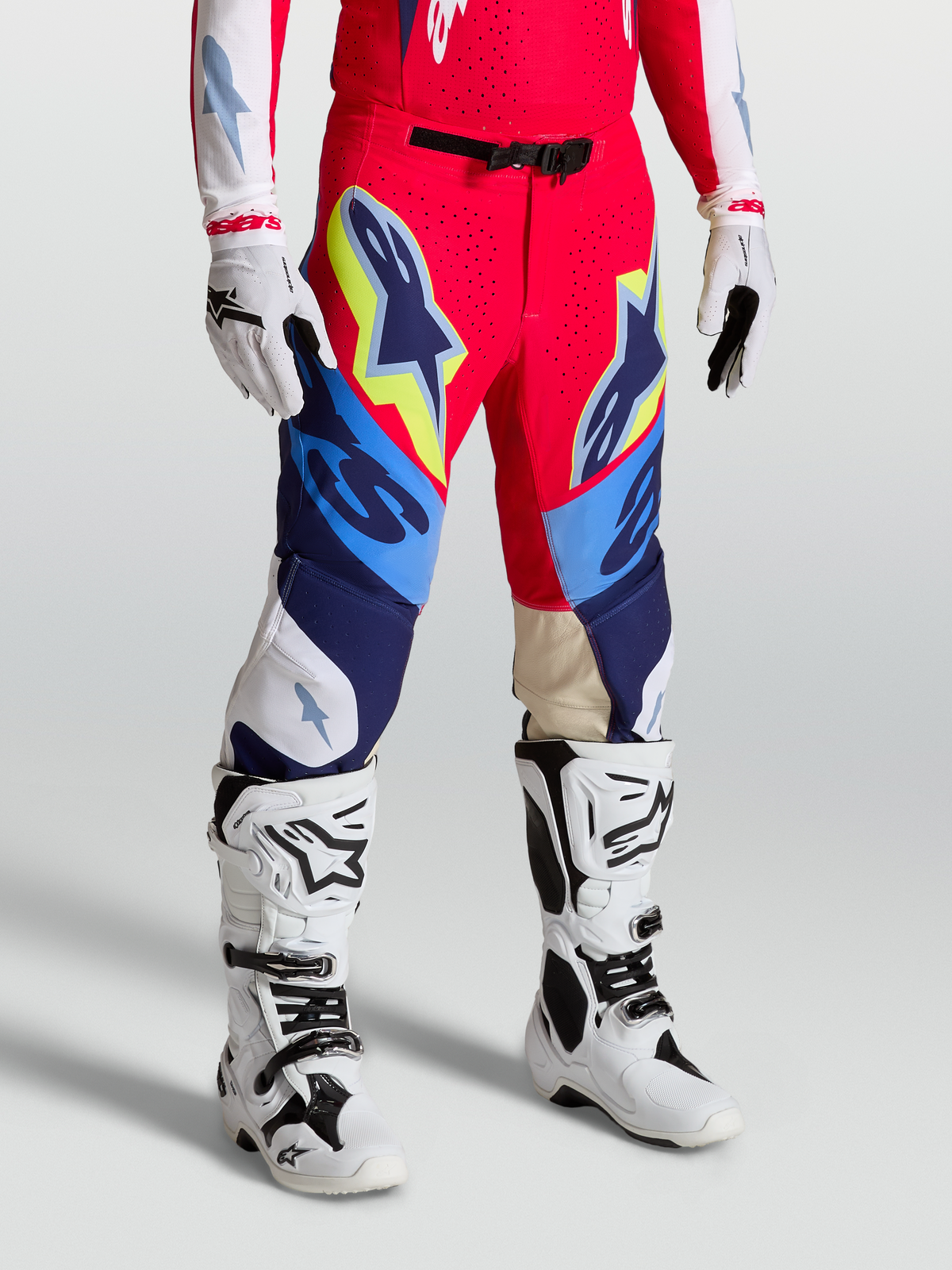 Alpinestars Pantaloni Supertech Dyna, pantaloni da motocross racing, rosso fuoco, bianco e blu navy, vestibilità atletica con fibbia magnetica e ginocchia in pelle, indossati con stivali e guanti bianchi