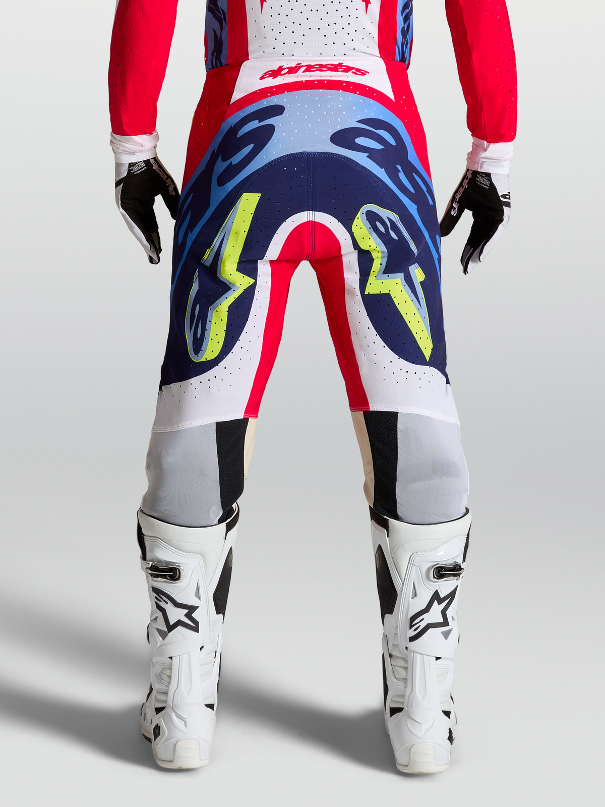 Alpinestars Pantaloni Supertech Dyna, pantaloni da motocross professionali, rosso fuoco, bianco e blu navy, vista posteriore con costruzione stretch resistente per performance racing